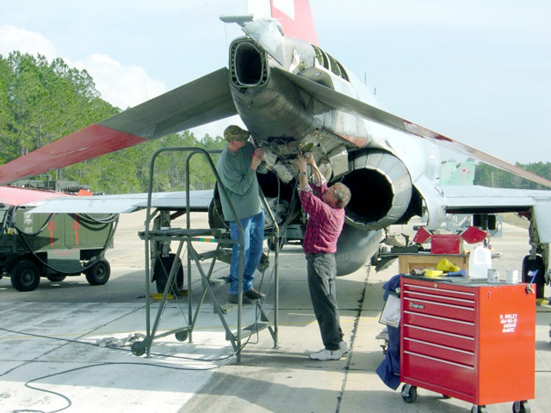 TYNDALL AIR FORCE BASE, Fla. -- James Gunn (left) and Gene Fischer remove damaged titanium blast shields from a QF-4 Phantom II here.  They are aircraft structural engineers.  Mr. Gunn is from Hill Air Force Base, Utah.  Mr. Fischer is from the Aerospace Maintenance and Regeneration Center at Davis-Monthan AFB, Ariz.  (U.S. Air Force photo by Dave Peterson) 