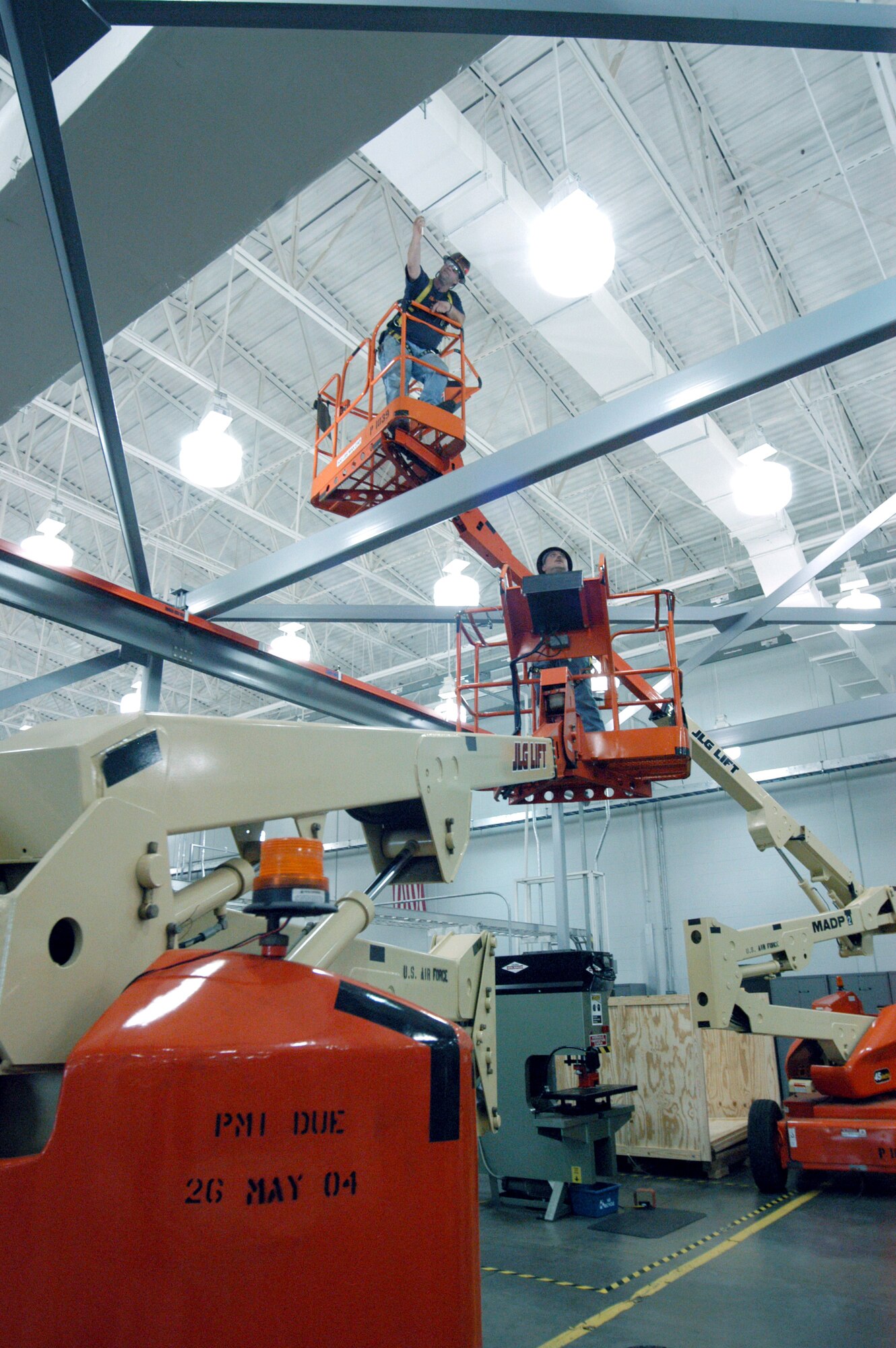 ROBINS AIR FORCE BASE, Ga. -- Ken Zwitch (left) and Buck Roland use lifts to check out a building's beams.  Both men are millwrights, or metal structure mechanics, here.  (U.S. Air Force photo by Sue Sapp)