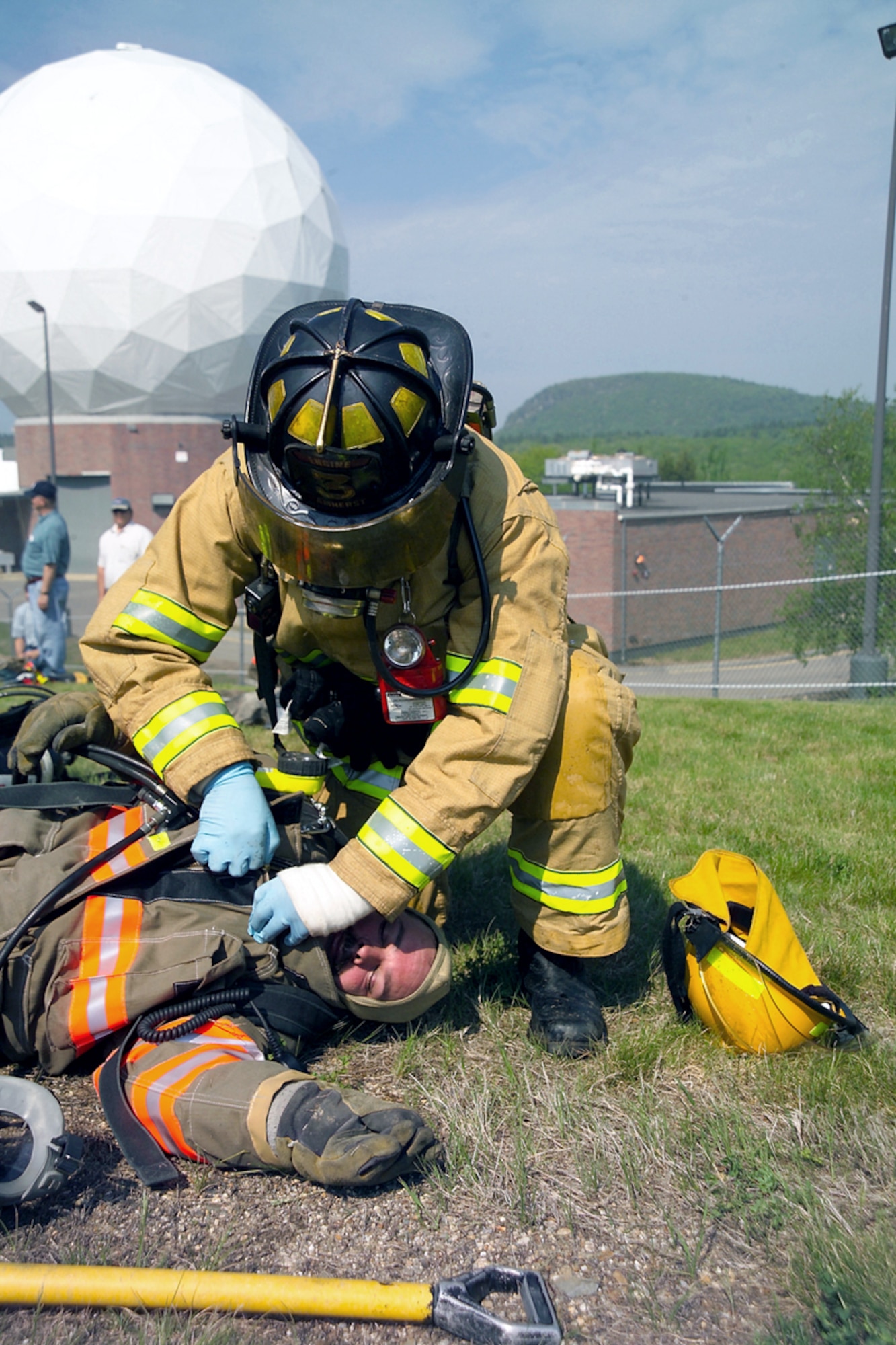 NEW BOSTON AIR FORCE STATION, N.H. -- A firefighter from nearby Amherst starts decontaminating a fellow firefighter exposed to a "chemical agent" here during an exercise here May 15.  The exercise, called Granite Thunder 2004, encompassed more than 20 local, state and federal agencies to respond to a simulated terrorist attack that combined explosives with chemical agents.  (U.S. Air Force photo by Mark Wyatt)