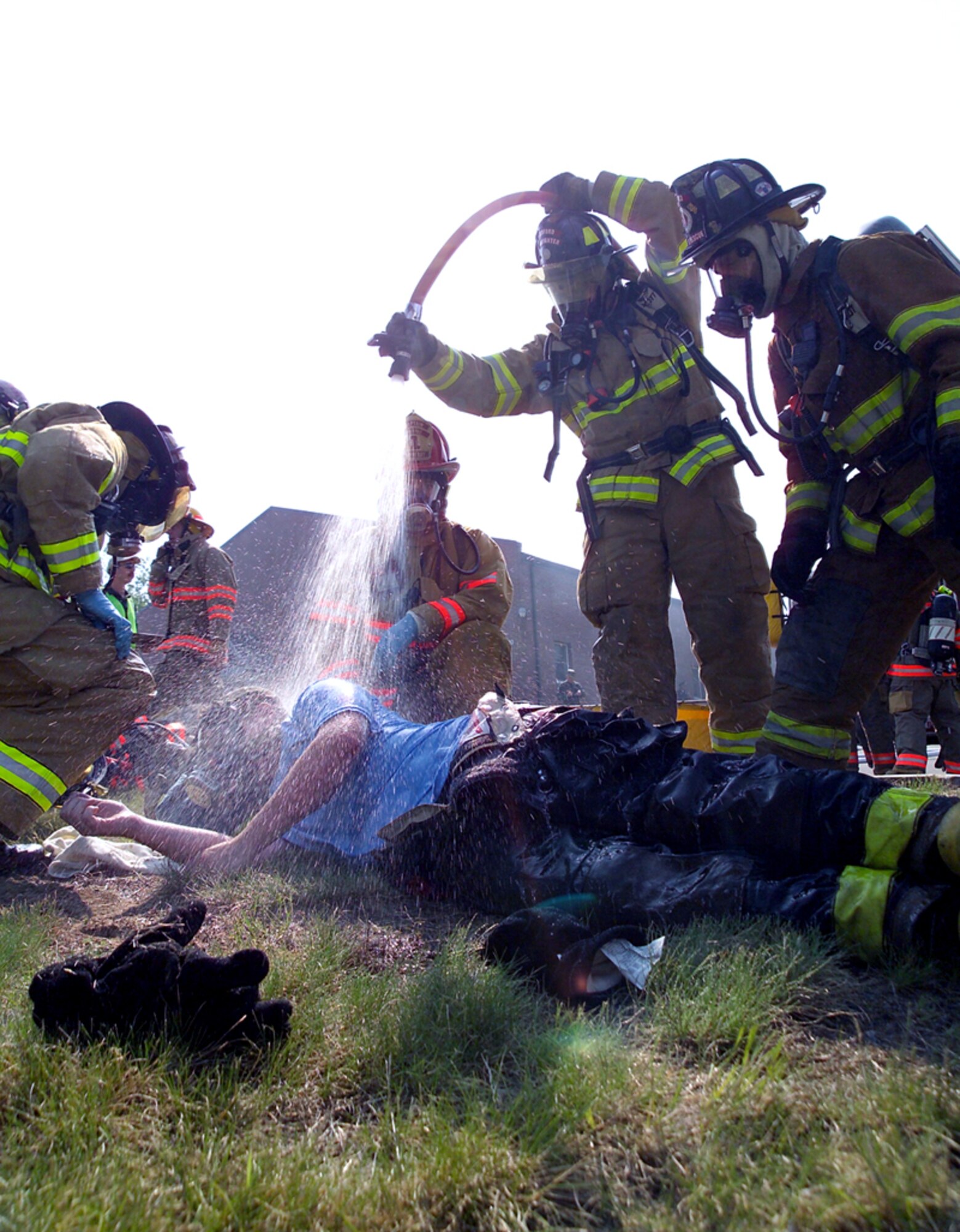 NEW BOSTON AIR FORCE STATION, N.H. -- A firefighter from nearby Bedford starts decontaminating a fellow firefighter exposed to a "chemical agent" during an exercise here May 15.  The exercise, called Granite Thunder 2004, encompassed more than 20 local, state and federal agencies responding to a simulated terrorist attack that combined explosives with chemical agents.  (U.S. Air Force photo by Mark Wyatt)