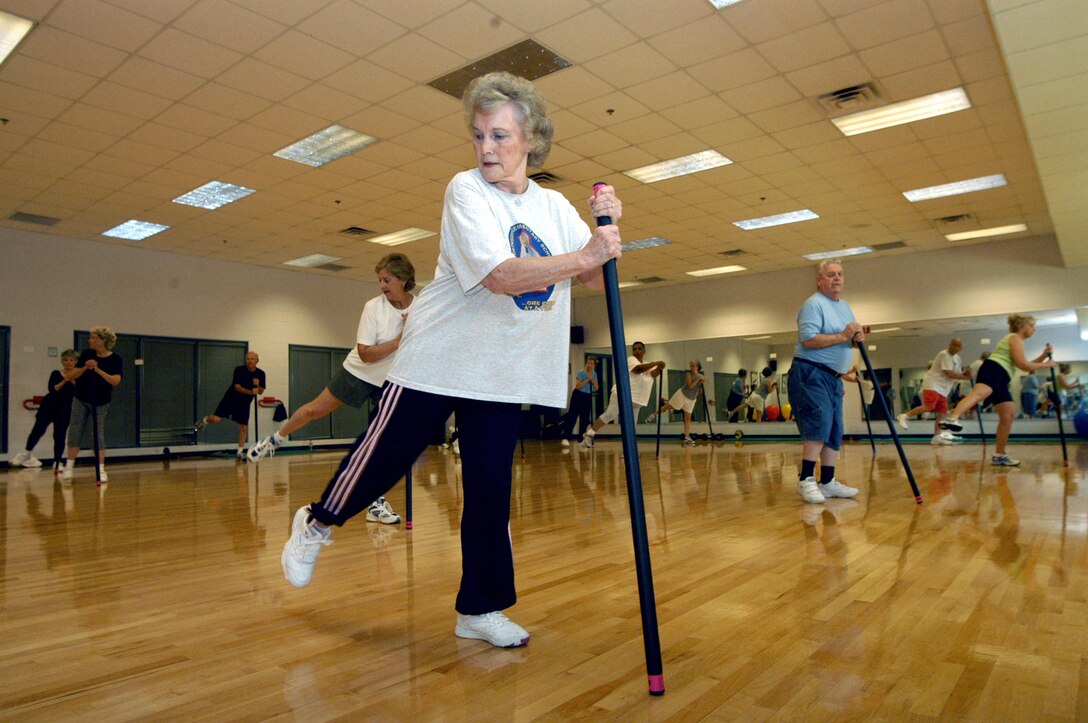 ROBINS AIR FORCE BASE, Ga. -- Bobbie Dixon (foreground) uses an exercise pole while doing Tae Bo at the fitness center here May 10.  The senior Tae Bo class incorporates boxing moves into a high-energy aerobics routine, modified with balancing poles to ensure participants' safety.  (U.S. Air Force photo by Sue Sapp)