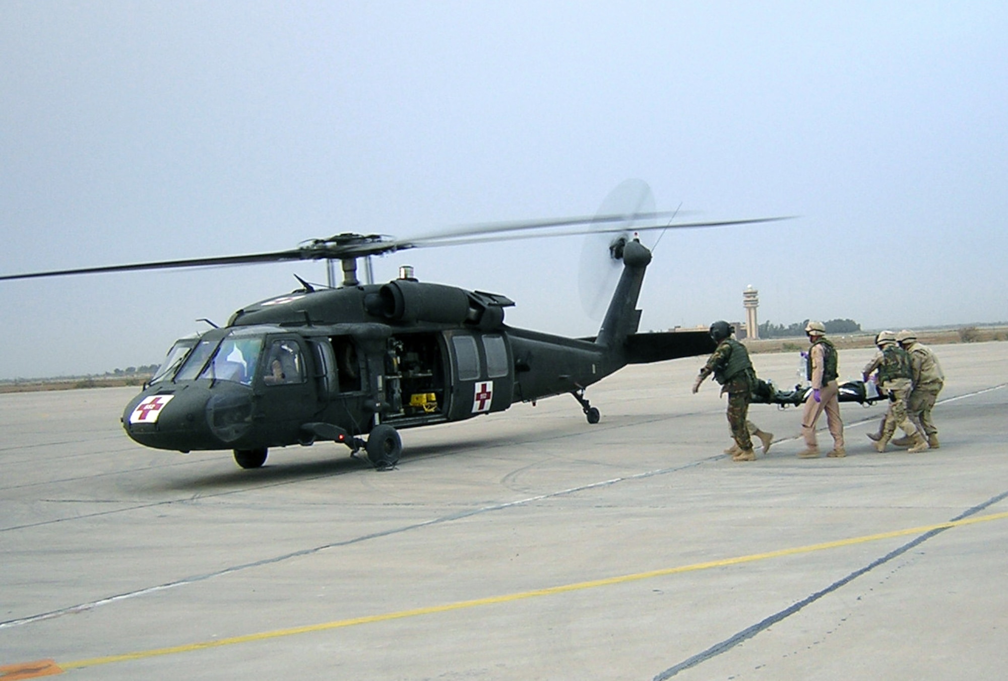 CAMP SATHER, Iraq -- Medical technicians from the 447th Expeditionary Medical Squadron here load up patients during a scheduled aeromedical evacuation.  Many of the aeromedical evacuations from here occur at night, requiring a high degree of competence and teamwork from the technicians to prevent further injury or pain to the patients.   (U.S. Air Force photo)