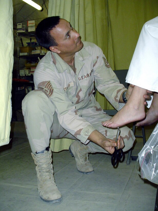 CAMP SATHER, Iraq -- Tech. Sgt. Sterling Castillo checks reflexes on a patient having an allergic reaction to a possible insect bite.  Sergeant Castillo is an independent duty medical technician with the 447th Expeditionary Medical Squadron here.  Airmen in the squadron provide care ranging from sick-call service to emergency surgery.  (U.S. Air Force photo by Master Sgt. Sean E. Cobb)
