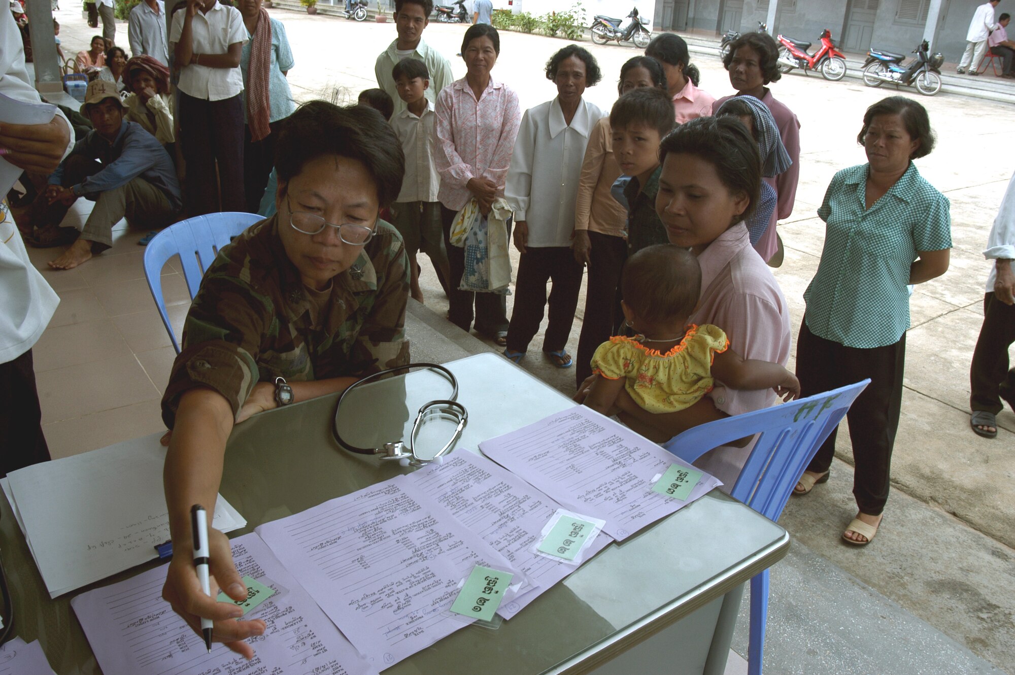 KEP, Cambodia -- Lt. Col. Diep Duong reviews a patient's screening paperwork as she assesses possible patients in a hospital compound here.  Colonel Duong is the leader of a 20-person blast resuscitation and victim assistance team on a two-week humanitarian mission here.  Colonel Duong is a nurse assigned to Detachment 2 of the 13th Air Force international health specialist program at Hickam Air Force Base, Hawaii.  (U.S. Air Force photo by Master Sgt. Adam Johnston)