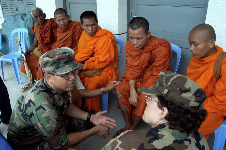 KEP, Cambodia -- Maj. Vira Em translates a monk's symptoms for Navy Capt. Faye Pyles on May 17.  They are part of a 20-person blast resuscitation and victim assistance team that arrived here for a two-week humanitarian mission.  Major Em is an active-duty bioenvironmental engineering technical adviser assigned to Air National Guard headquarters at Andrews Air Force Base, Md.  Captain Pyles is a pediatric nurse practitioner assigned to the Portsmouth Naval Hospital, Va.  (U.S. Air Force photo by Master Sgt. Adam Johnston)