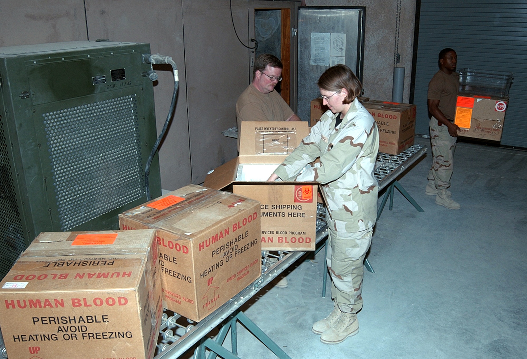 AL UDEID AIR BASE, Qatar -- (From left) Staff Sgt. Scott Tone, 1st Lt. Sara Hatcher and Airman 1st Class Covito Redman are part of the 379th Expeditionary Medical Group's blood transshipment center team.  The team receives blood from the distribution center at McGuire Air Force Base, N.J., and sends it anywhere in the theater of operations.  The Airmen are deployed from Davis-Monthan AFB, Ariz.  (U.S. Air Force photo by Airman 1st Class J.G. Buzanowski)