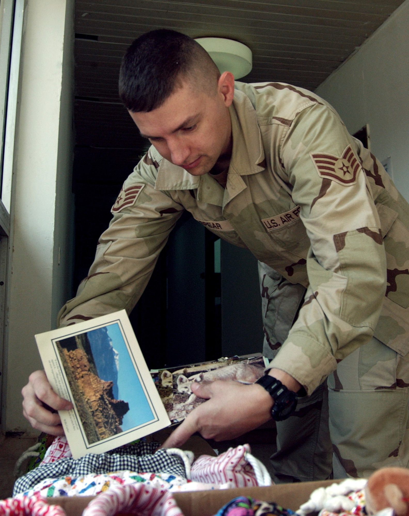 BALAD AIR BASE, Iraq -- Staff Sgt. Troy Spear puts post cards into bags of school supplies to be given to Iraqi children during a humanitarian mission to a small village near here.  About 30 Airmen and Soldiers traveled to the village to hand out school supplies and toys to the children collected by children from several schools in Florida.  Sergeant Spear is assigned to the 332nd Expeditionary Operations Support Squadron.  (U.S. Air Force photo by Master Sgt. Jon Hanson)