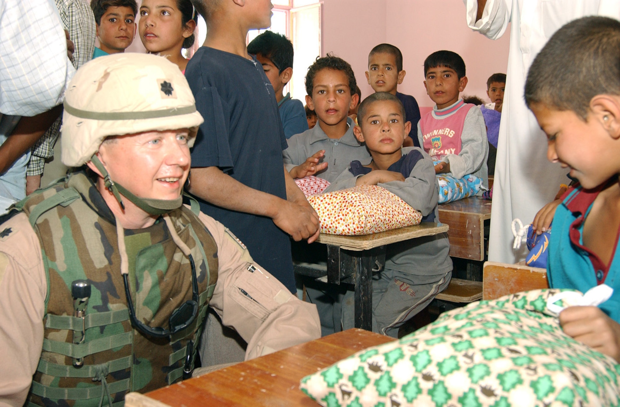 BALAD AIR BASE, Iraq -- Lt. Col. Craig King talks with an Iraqi boy at a small village near here during a humanitarian mission.  About 30 Airmen and Soldiers traveled to the village to hand out school supplies and toys to the children that had been collected by children from several schools in Florida.  Colonel King is the 332nd Air Expeditionary Wing safety chief.  (U.S. Air Force photo by Master Sgt. Jon Hanson)
