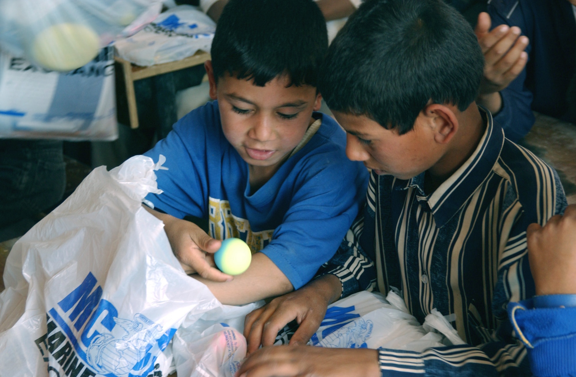 BALAD AIR BASE, Iraq -- Two young Iraqi children look at a ball they just received from Airmen and Soldiers at a village near here as part of a humanitarian mission.  The servicemembers handed out school supplies and toys that had been collected by children from several schools in Florida.  (U.S. Air Force photo by Master Sgt. Jon Hanson)