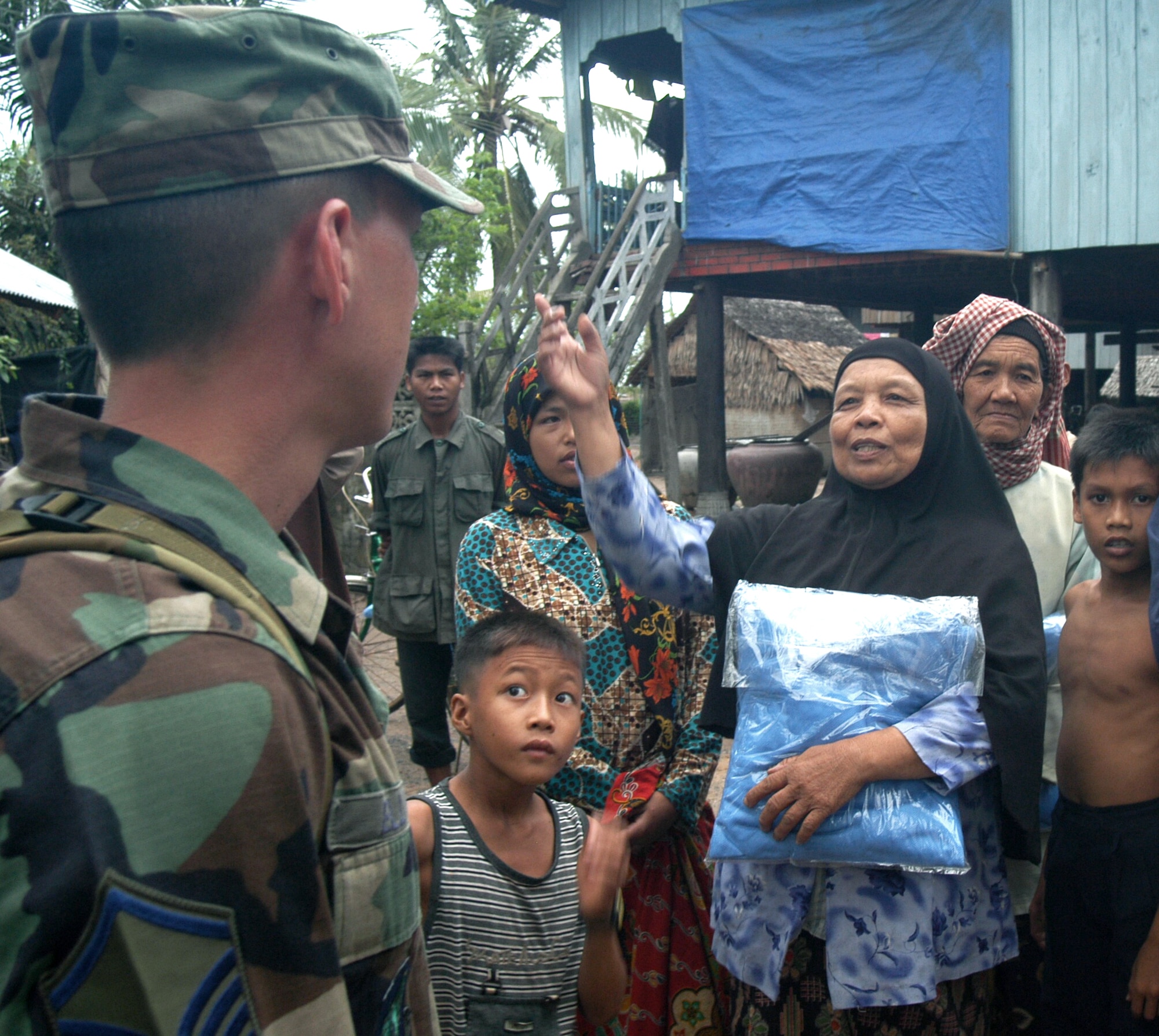 KEP, Cambodia -- Master Sgt. Dan Elliott talks with a Cham-Muslim woman in a village near here May 17 after handing out mosquito nets.  Sergeant Elliott is the noncommissioned officer in charge of a 20-person blast resuscitation and victim assistance team on a two-week humanitarian mission.  Sergeant Elliott is assigned to Detachment 2 of the 13th Air Force international health specialist program at Hickam Air Force Base, Hawaii. (U.S. Air Force photo by Master Sgt. Adam Johnston)