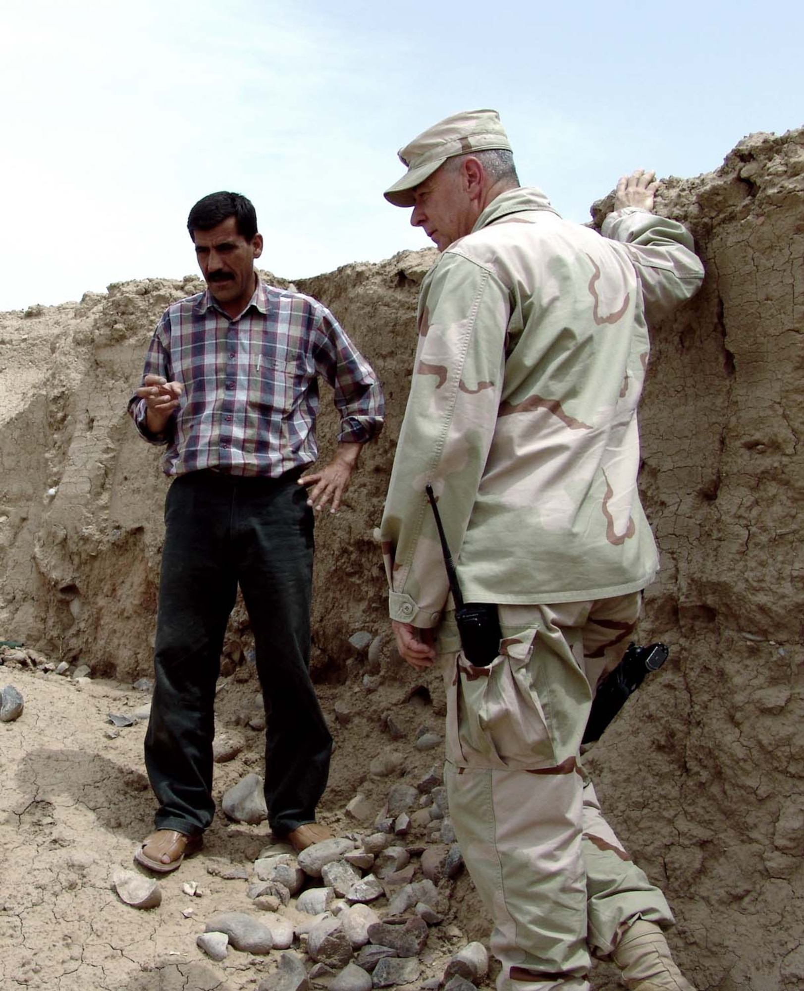 KIRKUK AIR BASE, Iraq -- Maj. Mike Larkin talks with Sheida Muhammad Amin at a recently discovered archeological site here.  Major Larkin is the 506th Expeditionary Security Forces Squadron commander, and Mr. Amin is an archeological surveyor for the Kirkuk's department of antiquities.  (U.S. Air Force photo by Maj. Charles Anthony)