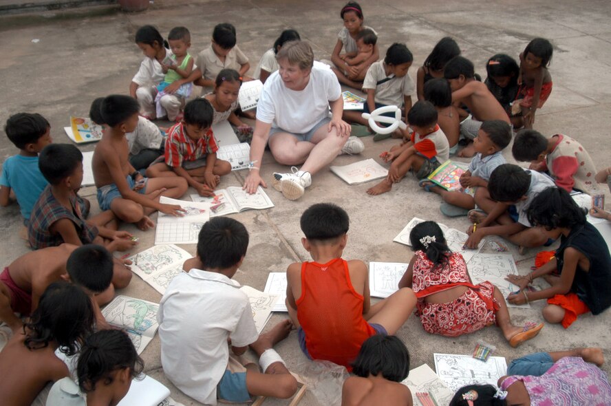 KEP, Cambodia -- Master Sgt. Rita Greiner leads a coloring book session with Cambodian children in a hospital compound here May 21.  Sergeant Greiner is an orthopedics technician and is part of a 20-person blast resuscitation and victim assistance team.  She is assigned to the 99th Medical Operations Squadron at Nellis Air Force Base, Nev.  (U.S. Air Force photo by Master Sgt. Adam Johnston)