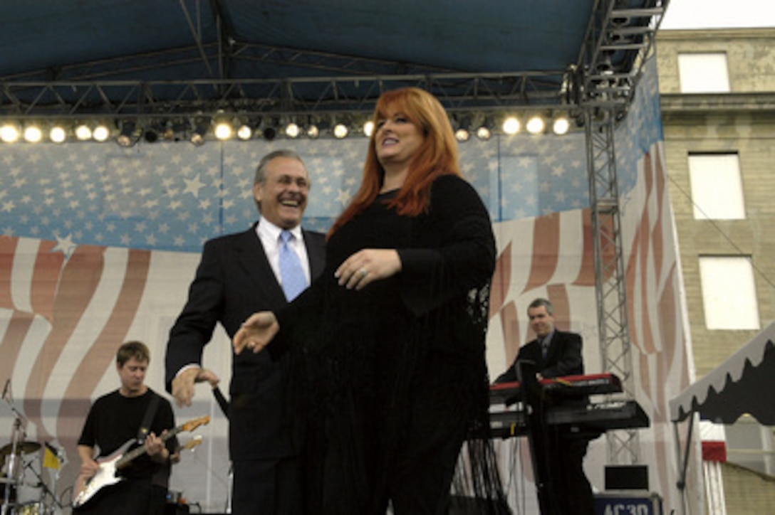 Country music singer Wynonna Judd makes her stage entrance after an introduction by Secretary of Defense Donald H. Rumsfeld at the Pentagon on May 21, 2004. Judd performed for an audience of military and DoD civilians that included military personnel recovering from wounds received in Iraq and Afghanistan. 