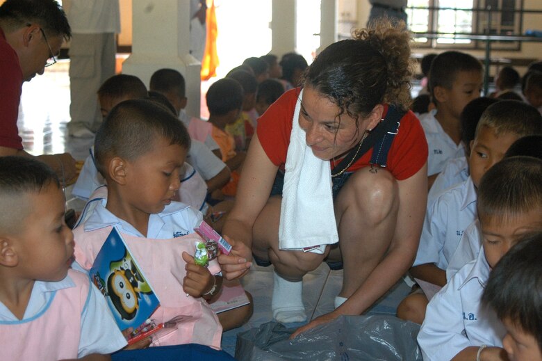 UDORN THANI, Thailand -- Tech. Sgt. Louise Arthur hands a child candy at a preschool near here.  Airmen from the 353rd Special Operations Group at Kadena Air Base, Japan, visited the preschool to donate supplies and improve the playground.  (U.S. Air Force photo by Master Sgt. Michael Farris)