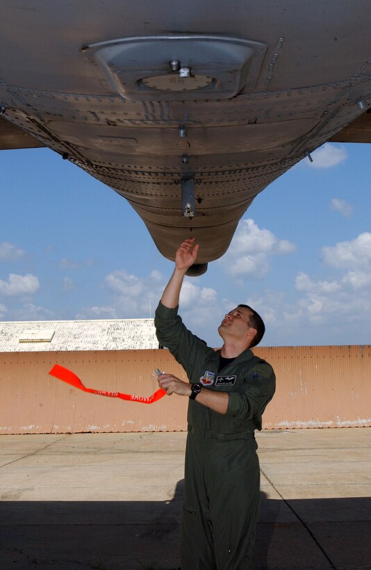 BARKSDALE AIR FORCE BASE, La. -- Capt. Marcus Glenn removes a safety pin from the flare door of a B-52 Stratofortress before a training mission from here May 20.  Captain Glenn is a B-52 electronic warfare officer assigned to the 340th Weapons School.  (U.S. Air Force photo by Airman Tabitha Wininger)