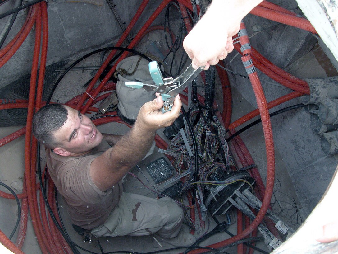 SOUTHWEST ASIA -- Senior Airman Jered Smither grabs a pair of wire crimpers to splice phone cables together at a forward-deployed location.  Airman Smither is assigned to the 379th Expeditionary Communication Squadron and is deployed from Andersen Air Base, Guam.  (U.S. Air Force photo by Senior Airman Wes Auldridge)
