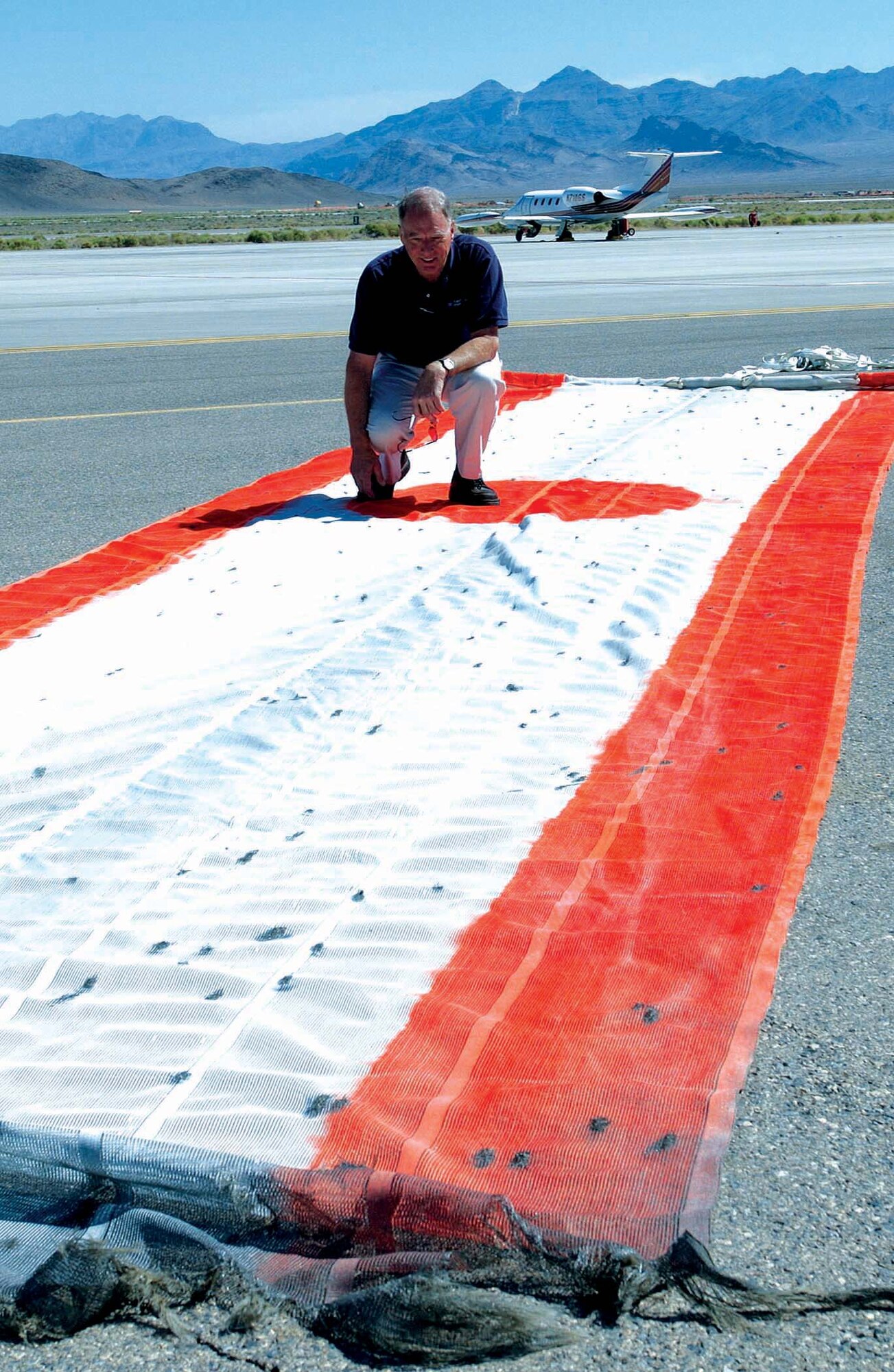 NELLIS AIR FORCE BASE, Nev. -- Retired Lt. Col. Jim Pressick counts the number of holes shot into a banner used for target practice by F-15 Eagle pilots during a training exercise May 20 over the Nevada Test and Training Range near here.  The banner was pulled behind a plane Colonel Pressick flew to give pilots air-to-air gunnery training.  The banner was shot 422 times.  (U.S. Air Force photo by Senior Airman Brian Ferguson)