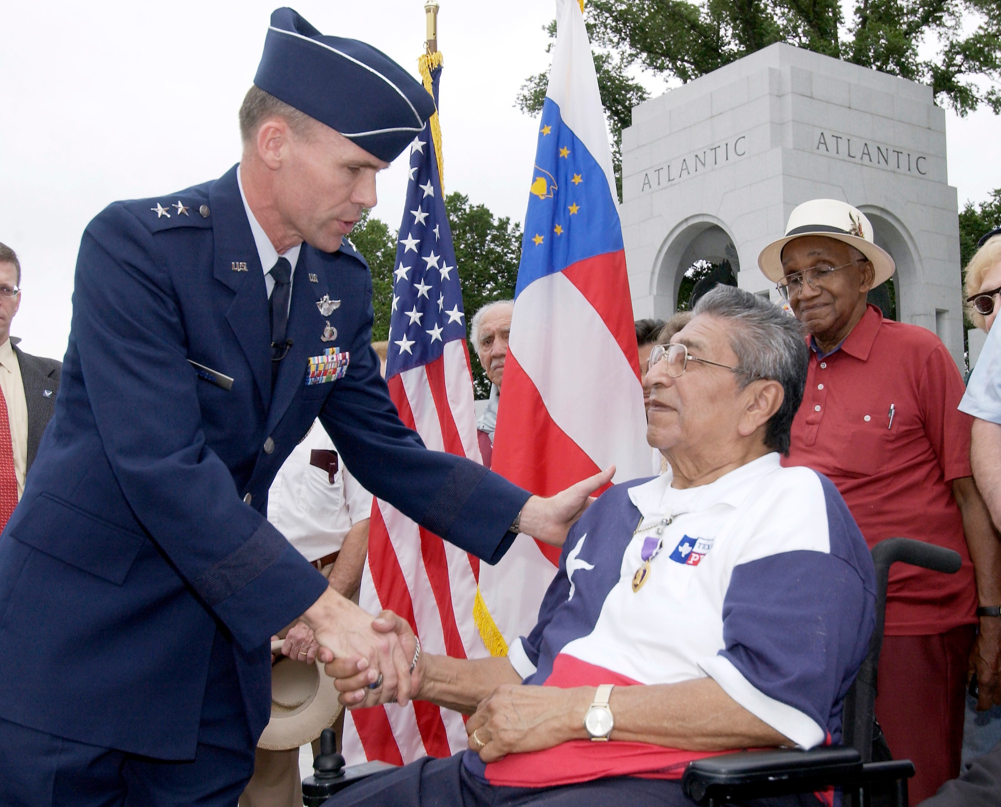 WASHINGTON -- Maj. Gen. John L. Hudson presents John Martinez with a Purple Heart during a ceremony at the World War II Memorial here May 28.  The presentation happened more than 59 years after the veteran's A-20 attack bomber crashed near Rhiems, France, causing a paralyzing spinal-cord injury.  Mr. Martinez was a staff sergeant serving as an aerial gunner on the A-20.  He was visiting here for the memorial's dedication.  General Hudson is the Joint Strike Fighter program director at the Pentagon.  (U.S. Air Force photo by Master Sgt. Jim Varhegyi)