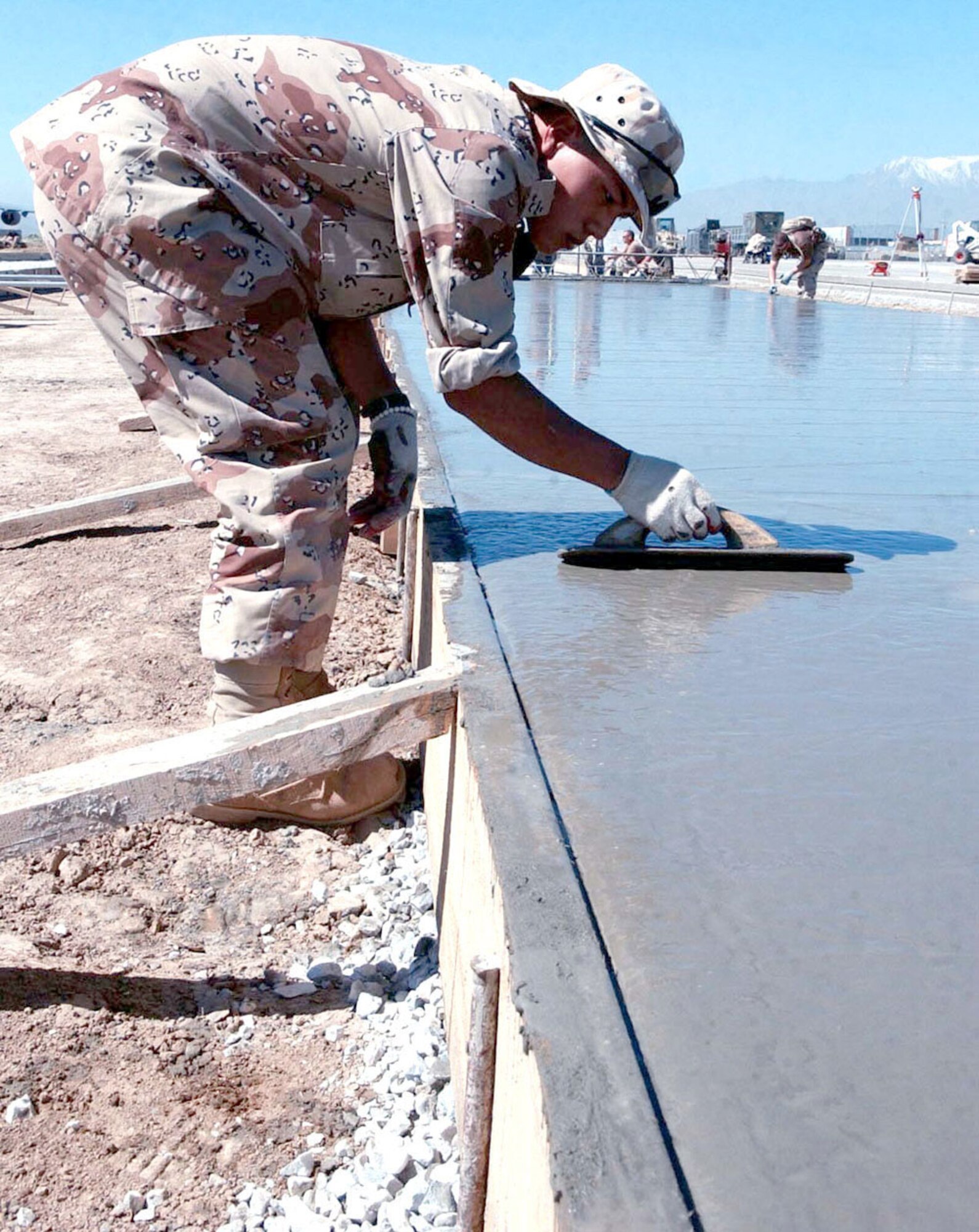 BAGRAM AIR BASE, Afghanistan -- South Korean army Pfc. Yi Dong Gon puts the finishing touches on concrete on the flightline here.  A South Korean-American engineering project expanded the flightline here by about 76,000 square feet.  Private Gon is an engineer with the 100th Korean Engineer Corps.  (U.S. Air Force photo by Master Sgt. Jeff Szczechowski)                     