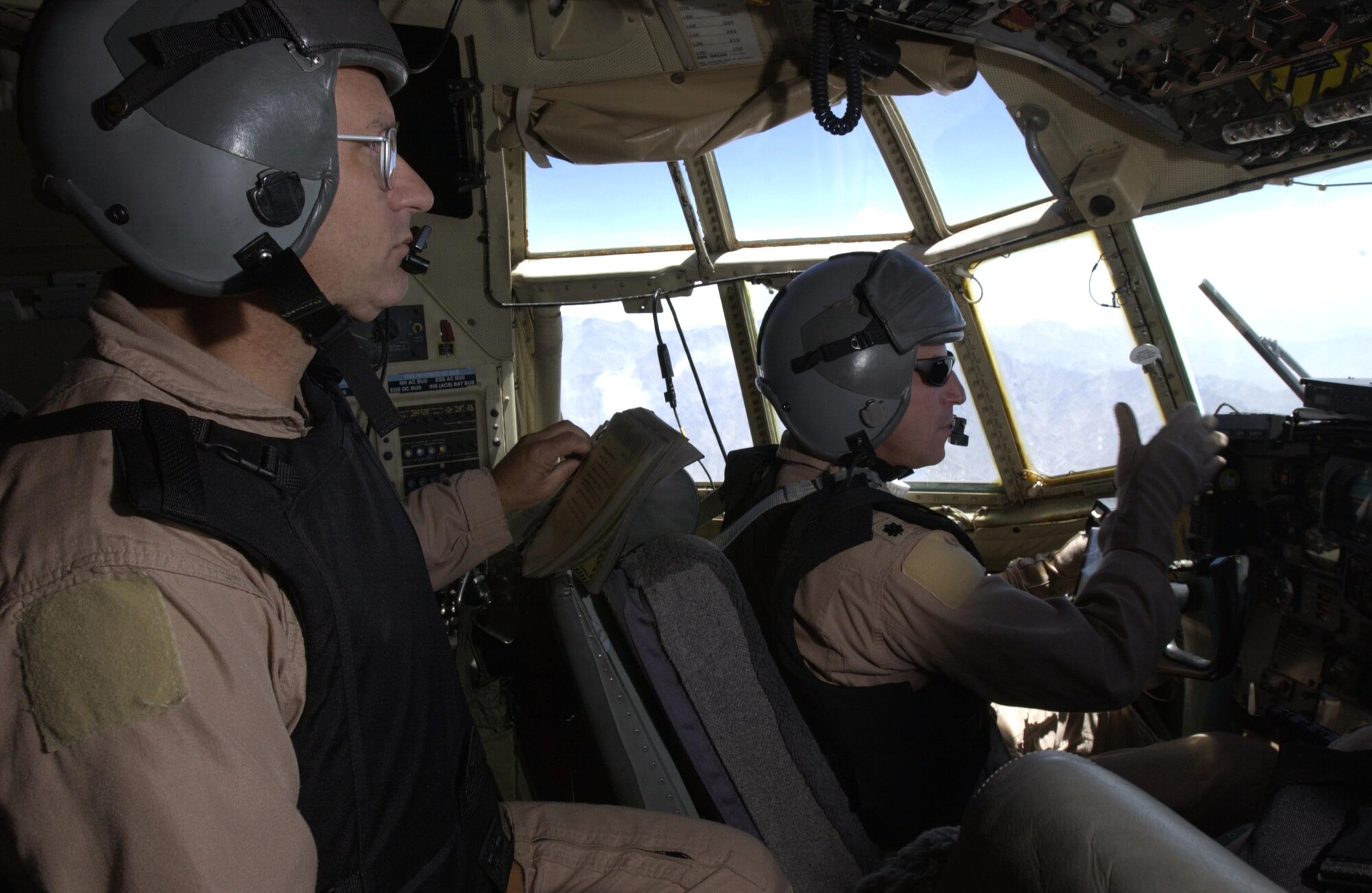 OVER AFGHANISTAN -- Master Sgt. Kenny Mullock (left) watches for stray aircraft while Lt. Col. Craig Wilds focuses on his approach.  During this mission, Airmen from the Missouri Air National Guard delivered 1,700 pounds of cargo and 14 passengers to Bagram Air Base, Afghanistan.  Sergeant Mullock is a flight engineer.  (U.S. Air Force photo Master Sgt. Scott Wagers)
