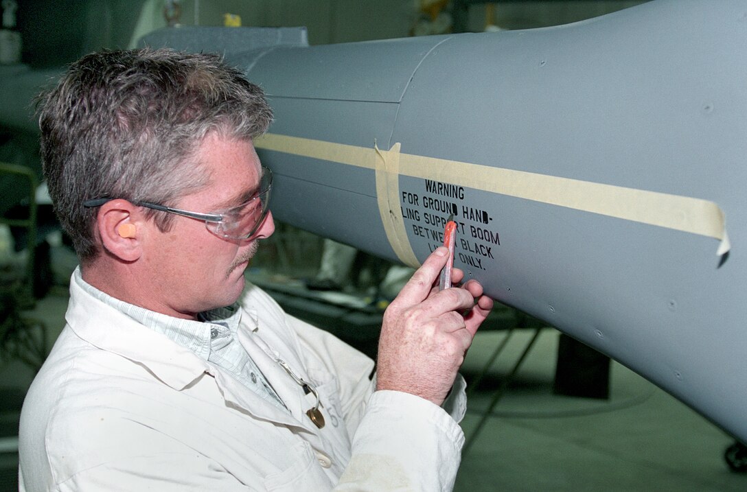 TINKER AIR FORCE BASE, Okla. -- Painter Steve Hamilton finishes stenciling on a KC-135 Stratotanker boom.  (U.S. Air Force photo by Margo Wright)
