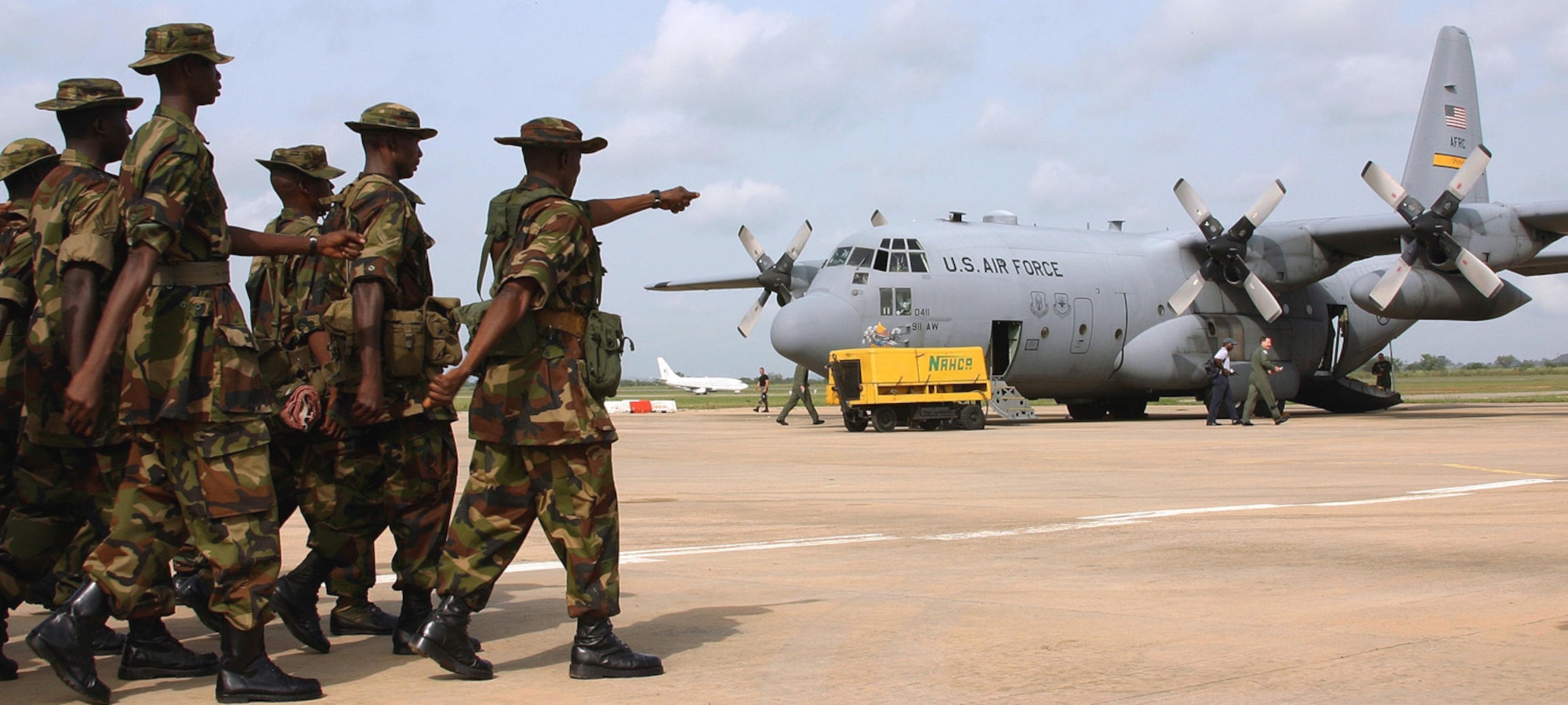 ABUJA, Nigeria -- Nigerian troops march toward an Air Force C-130 Hercules.  The aircraft flew them to the Sudan on Oct. 28.  President Bush sent two C-130s to the African Union to help reduce the humanitarian crisis in the Darfur region.  (U.S. Air Force photo by 1st Lt. John Beach)