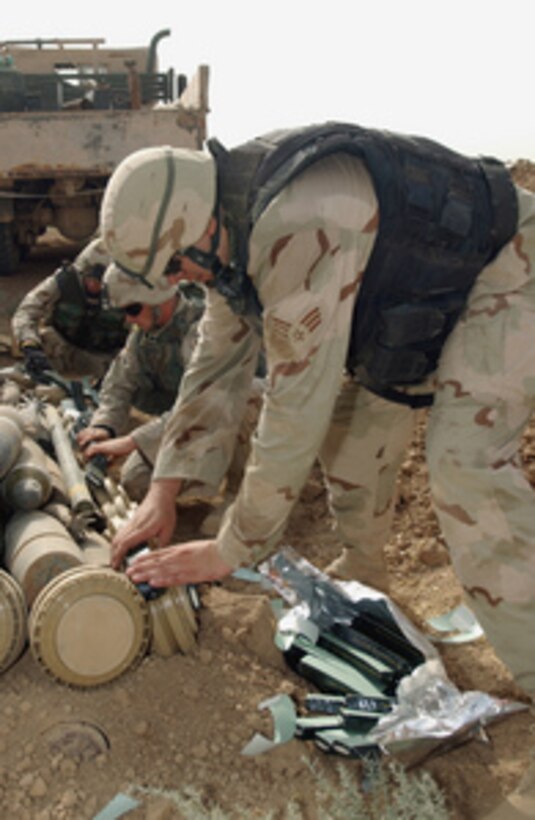 Senior Airman Randall Peterson attaches C4 explosive to a stack of live munitions that are set to be destroyed near Kirkuk Air Base, Iraq, on Oct. 28, 2004. The munitions have been found throughout the Kirkuk area. Peterson is assigned to the 52nd Civil Engineer Squadron Explosive Ordnance Disposal (EOD) Flight at Spangdahlem Air Base, Germany, deployed with the 506th Civil Engineer Squadron EOD Flight. 