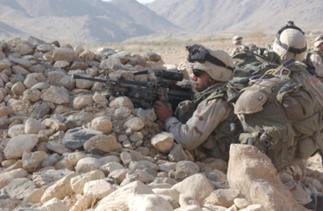 A U.S. Army soldier sets up a defensive position with his M-249 Squad Automatic Weapon during a patrol in the Daychopan District of Zabol Province, Afghanistan, on Oct. 23, 2004. Soldiers assigned to the 2nd Battalion, 35th Infantry Regiment, 25th Infantry Division are patrolling in the district. 