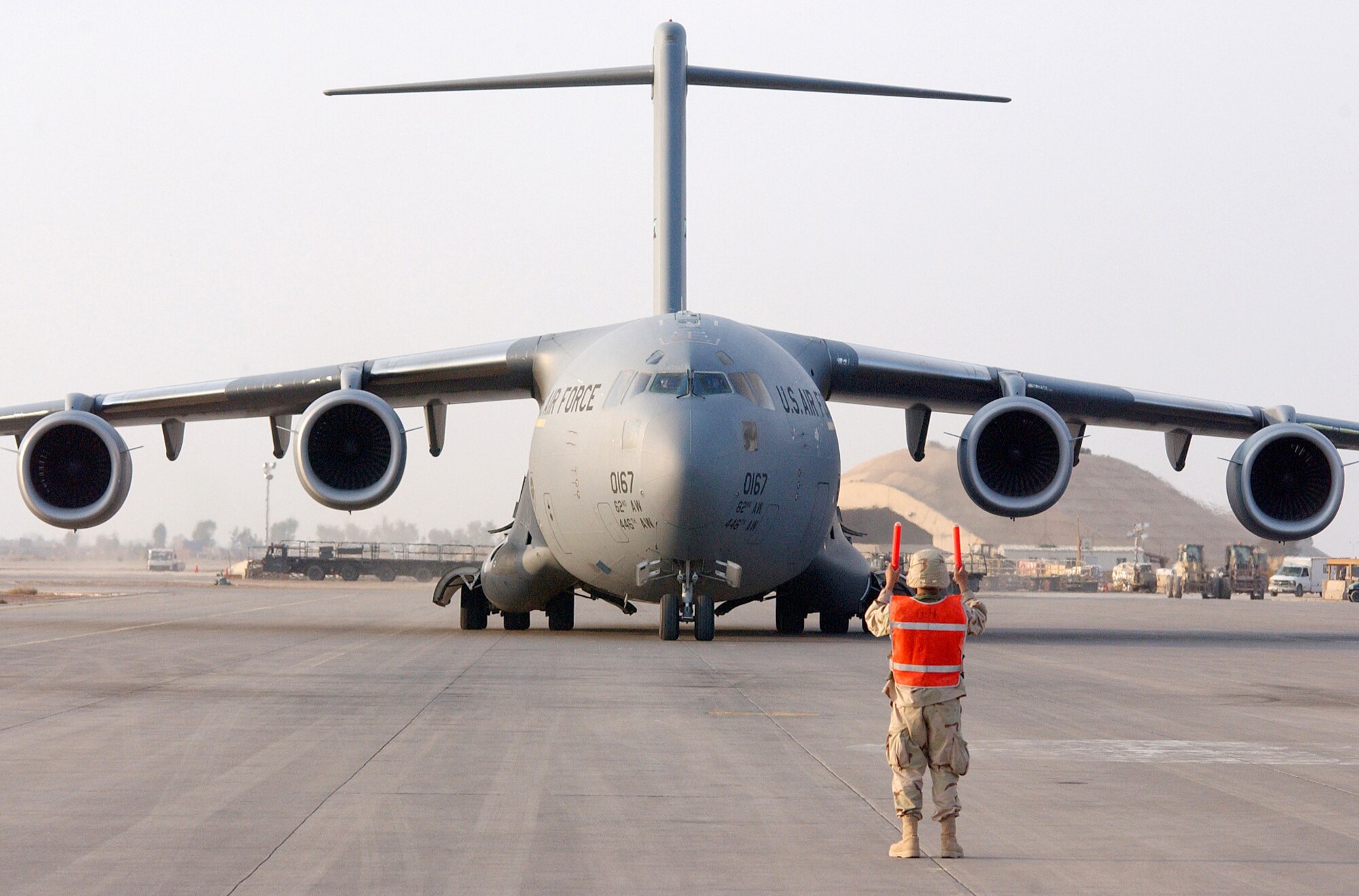 BALAD AIR BASE, Iraq -- Senior Airman Brandon Withers guides a C-17 Globemaster III to its parking spot on the flightline here Nov. 5.  Airman Withers is a 332nd Expeditionary Aircraft Maintenance Squadron jet engine mechanic deployed here from the 62nd Airlift Wing at McChord Air Force Base, Wash.  The 332nd EAMS is part of the 332nd Air Expeditionary Wing, the only Air Force wing in Iraq.  (U.S. Air Force photo by Staff Sgt. Marc Barnes)
