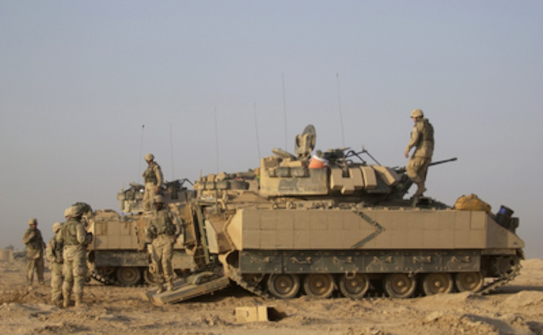 U.S. Army soldiers prepare themselves and their M2A2 Bradley Fighting Vehicles for an up coming mission at Forward Operating Base MacKenzie in Iraq on Oct. 28, 2004. The soldiers are assigned to Bravo Troop, 1st Battalion, 4th Cavalry Regiment, 1st Infantry Division. 