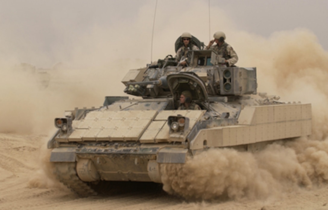 An M2A2 Bradley Fighting Vehicle kicks up plumes of dust as it leaves Forward Operating Base MacKenzie in Iraq for a mission on Oct. 30, 2004. The Bradley is assigned to Alpha Troop, 1st Battalion, 4th Cavalry Regiment, 1st Infantry Division. 