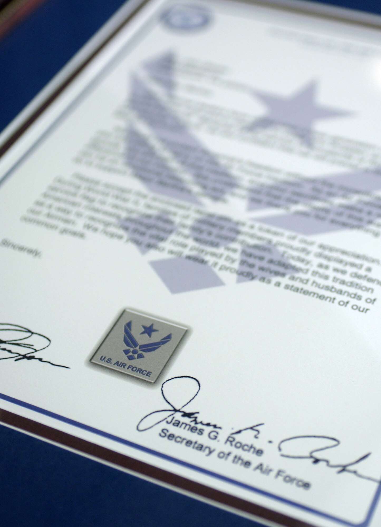 WASHINGTON -- A letter signed by Secretary of the Air Force James G. Roche and Chief of Staff of the Air Force Gen. John P. Jumper accompanies each Air Force spouse pin.  The pin is designed to recognize and thank spouses who support the efforts of Airmen stationed worldwide.  The pin sports a blue star cradled in the Air Force symbol.  It is a contemporary adaptation of a wartime tradition dating back to World War I where families hung service flags in their windows displaying a blue star for each family member serving in the armed forces.  Undersecretary of the Air Force Peter B. Teets launched the spouse pin program during a ceremony at the Pentagon on Nov. 8.  (U.S. Air Force photo by Master Sgt. Jim Varhegyi)