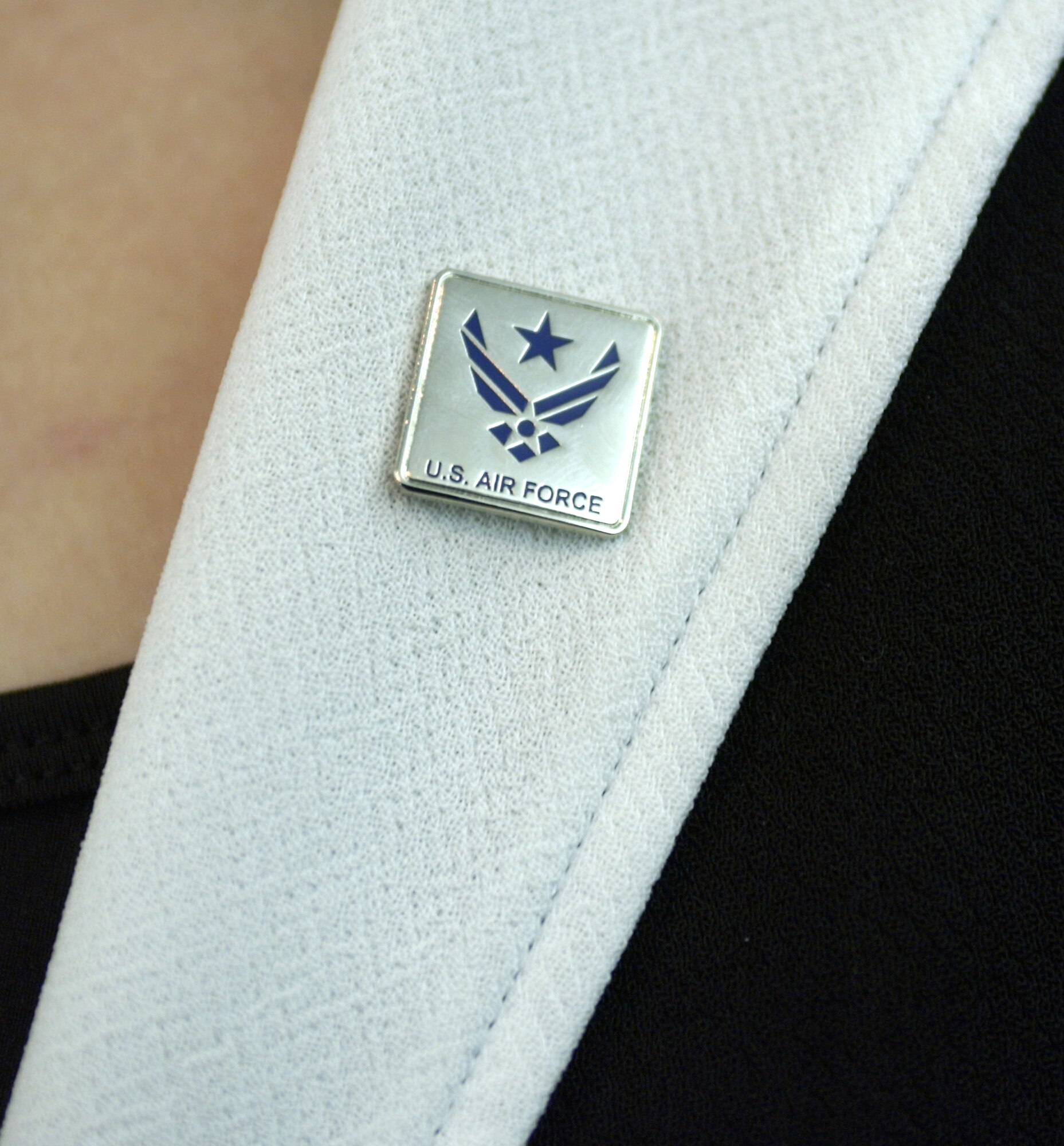 WASHINGTON -- The Air Force spouse pin sports a blue star cradled in the Air Force symbol.  The pin is designed to recognize and thank spouses who support the efforts of Airmen stationed worldwide.  It is a contemporary adaptation of a wartime tradition dating back to World War I where families hung service flags in their windows displaying a blue star for each family member serving in the armed forces.  Undersecretary of the Air Force Peter B. Teets launched the spouse pin program during a ceremony at the Pentagon on Nov. 8.  (U.S. Air Force photo by Master Sgt. Jim Varhegyi)