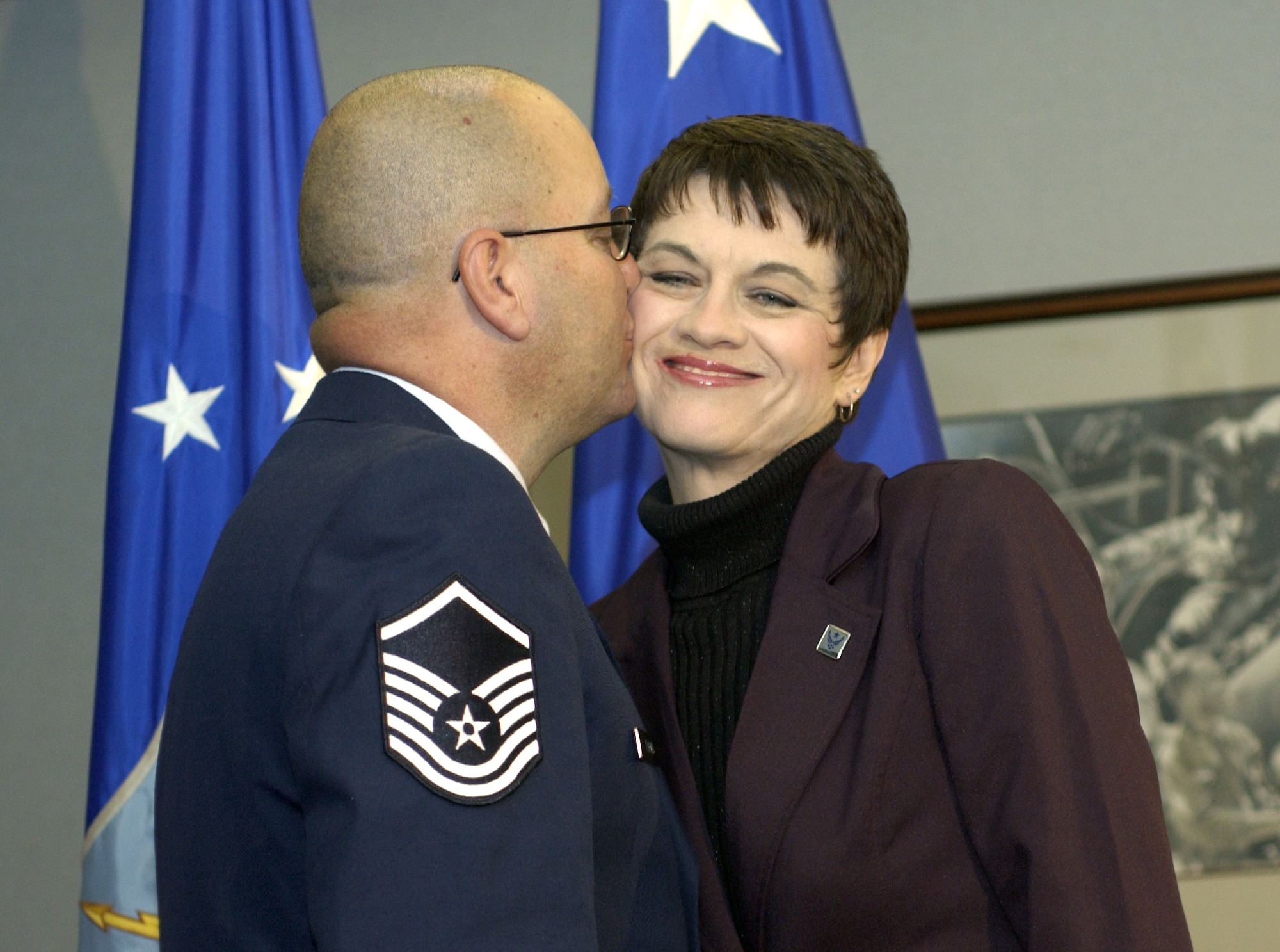 WASHINGTON -- Sandra Forney gets a kiss from her husband, Master Sgt. Glenn Forney, after receiving her spouse pin during a Pentagon ceremony Nov. 8.  The ceremony launched the spouse pin program.  The pin is designed to recognize and thank spouses who support the efforts of Airmen stationed worldwide.  Sergeant Forney is an Air National Guardsman with the 113th Logistics Readiness Squadron at Andrews Air Force Base, Md.  (U.S. Air Force photo by Master Sgt. Jim Varhegyi)