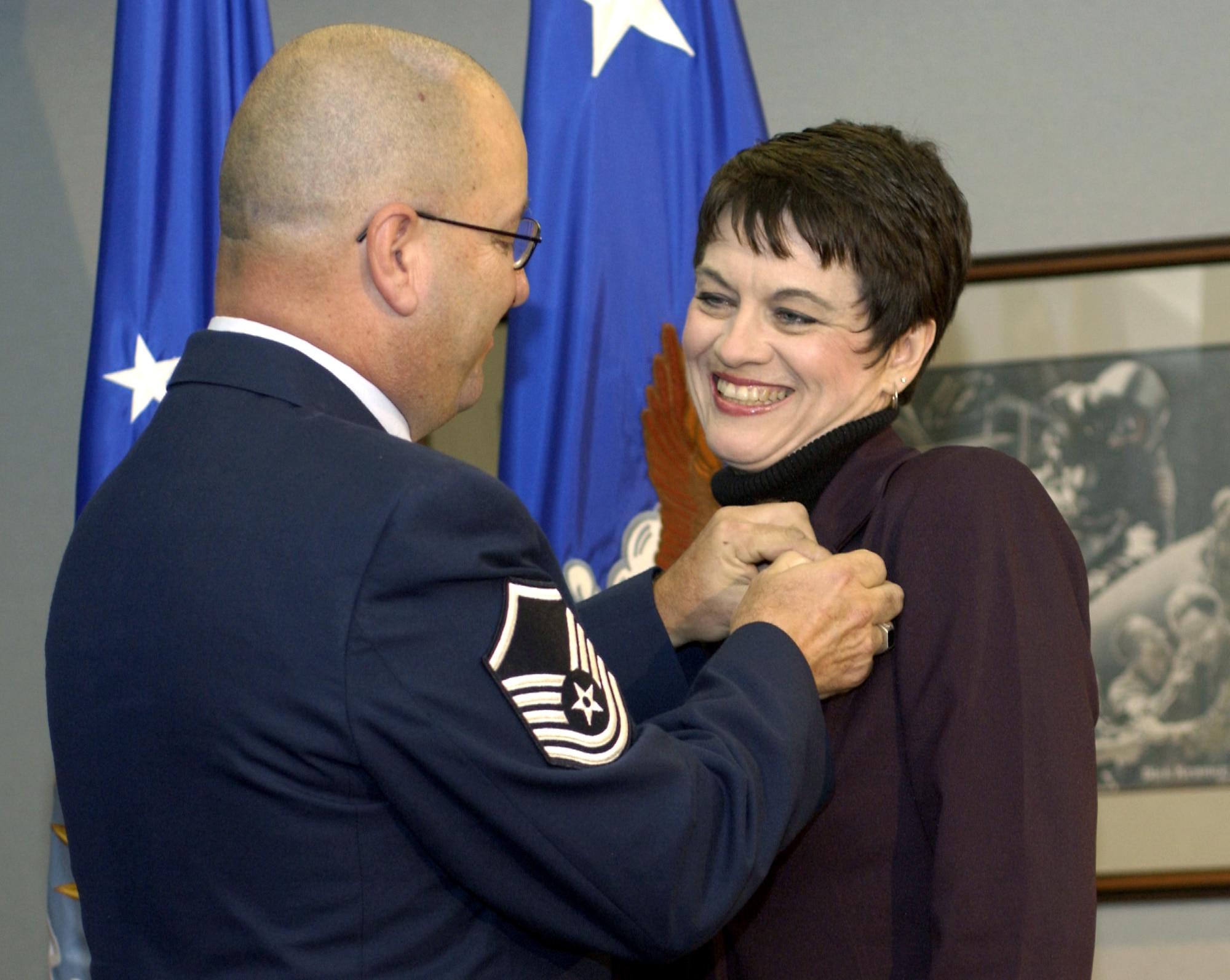 WASHINGTON -- Master Sgt. Glenn Forney fastens a spouse pin on his wife, Sandra, during a Pentagon ceremony Nov. 8.  The ceremony launched the spouse pin program.  The pin is designed to recognize and thank spouses who support the efforts of Airmen stationed worldwide.  Sergeant Forney is an Air National Guardsman with the 113th Logistics Readiness Squadron at Andrews Air Force Base, Md.  (U.S. Air Force photo by Master Sgt. Jim Varhegyi)
