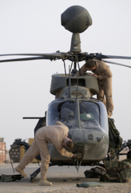 Army Chief Warrant Officer Bernd Knox and Capt. David Hnyda conduct a pre-flight inspection on a OH-58D Kiowa Warrior helicopter before flying a mission from Forward Operating Base MacKenzie in Iraq on Oct. 25, 2004. Knox and Hnyda are assigned to Delta Troop, 1st Battalion, 4th Cavalry Regiment, 1st Infantry Division. 