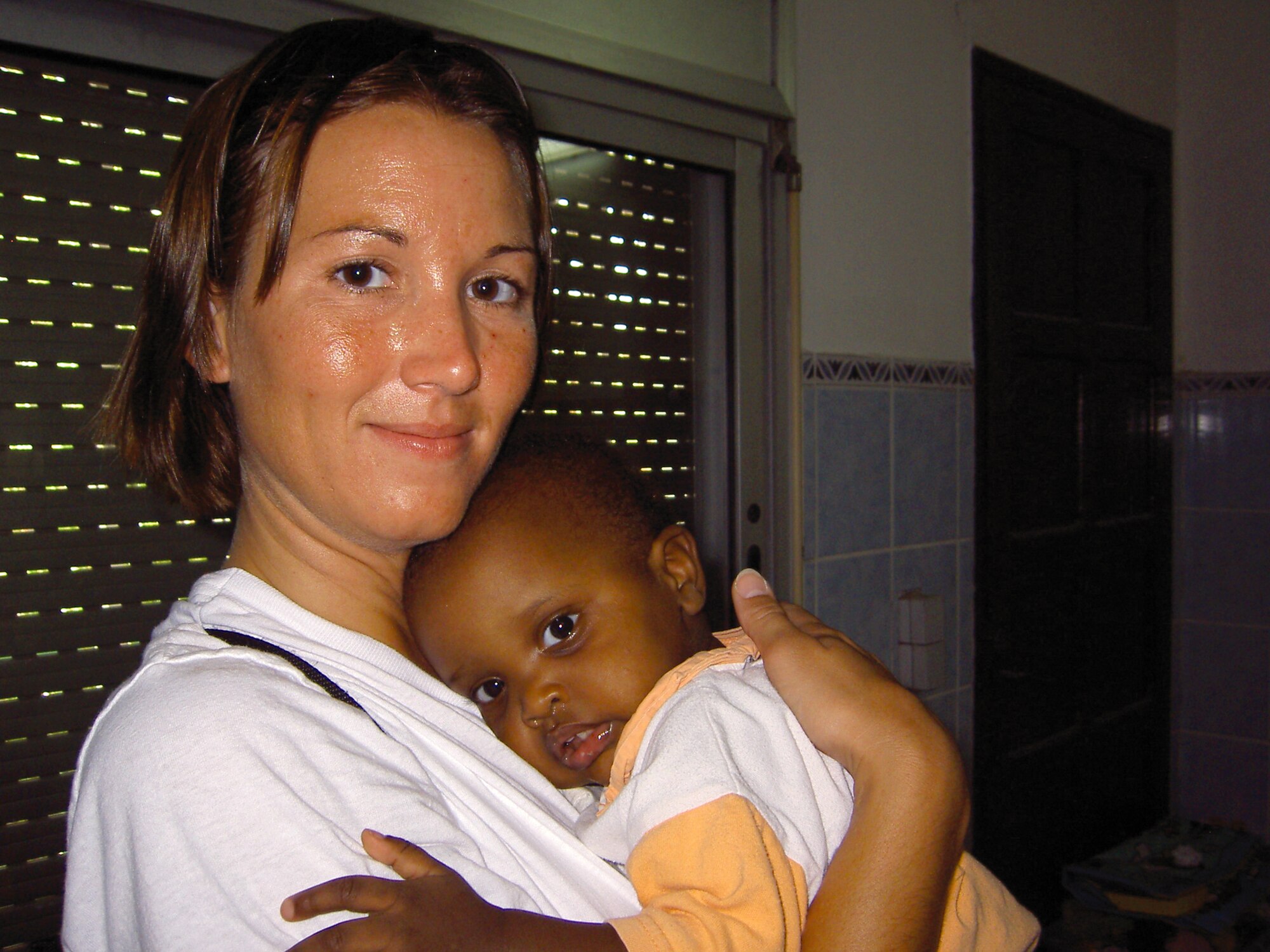 DJIBOUTI -- Capt. Karen Mensen shares a moment with one of 30 children at an orphanage.  She and other Airmen on her medical evacuation crew volunteered at the orphanage while deployed here.  Captain Mensen is a flight nurse deployed from the Minnesota Air National Guard's 109th Aeromedical Evacuation Squadron.  (U.S. Air Force photo by Staff Sgt. Connie Campbell)