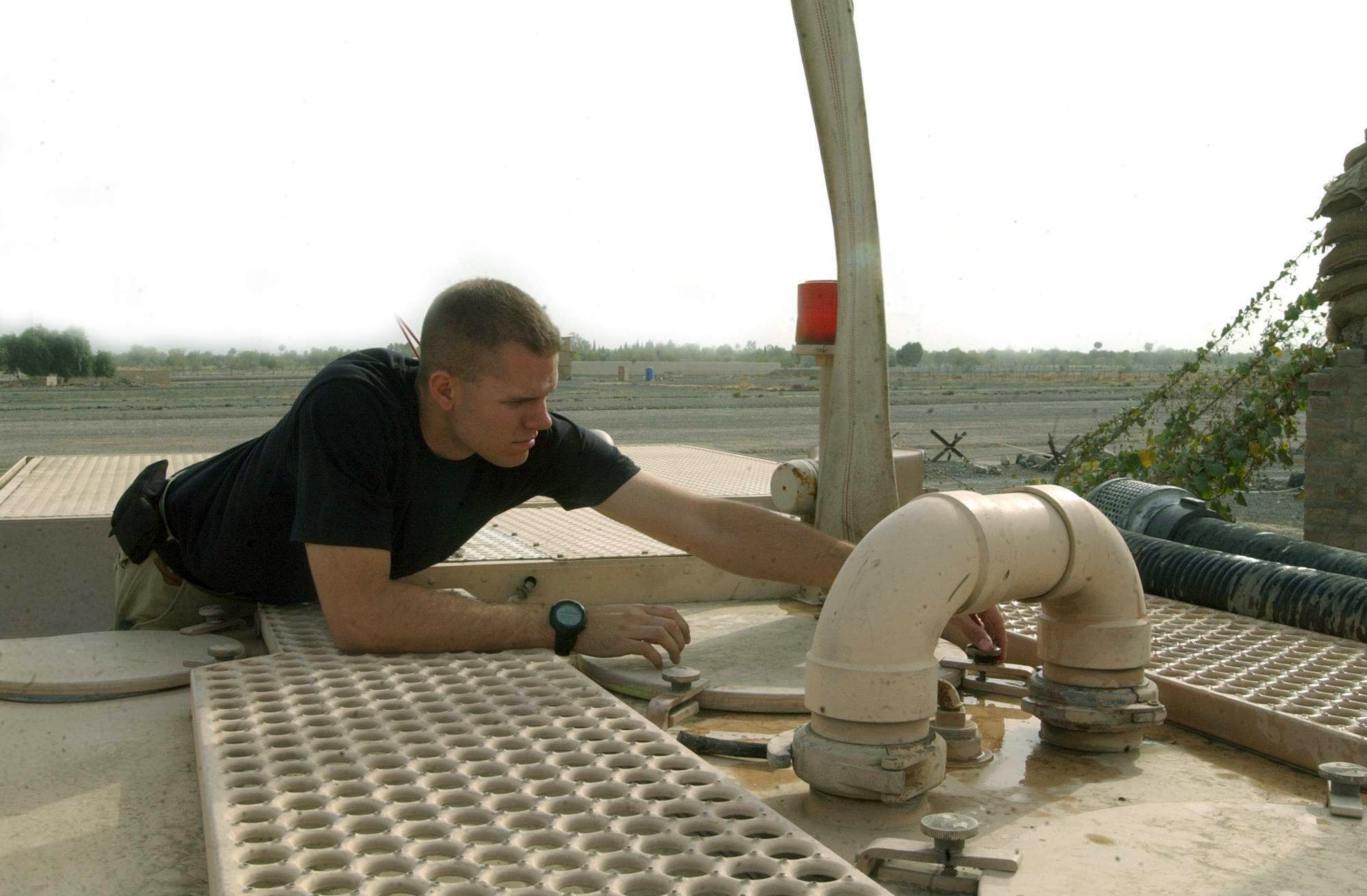 FORWARD OPERATING BASE SALERNO, Afghanistan -- Senior Airman Sean Barnette secures the lid on a fire truck reservoir here after ensuring it is full for the next emergency.  Airman Barnette is a firefighter with the 376th Expeditionary Civil Engineer Squadron from Manas Air Base, Kyrgyz Republic.  Airmen from Manas AB rotate duty here so the base has fire protection.  (U.S. Army photo by Army Spc. Cheryl Ransford)

