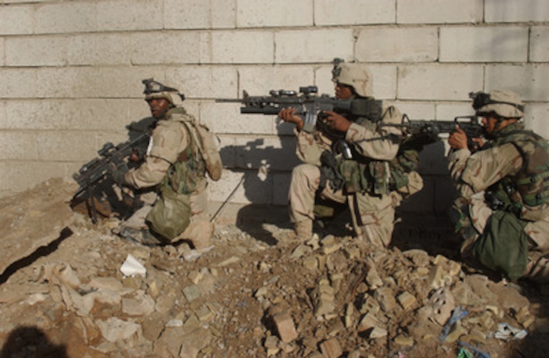 U.S. Army soldiers move along a wall as they clear buildings around their main objective in Fallujah, Iraq, during Operation al Fajr (New Dawn) on Nov. 9, 2004. The soldiers are assigned to 2nd Battalion, 7th Cavalry Regiment. 