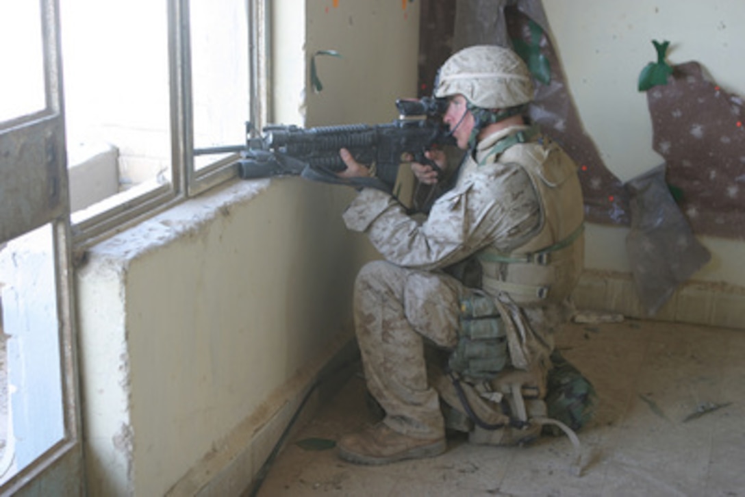 A U.S. Marine watches for anything suspicious from a building in Fallujah, Iraq, during Operation al Fajr (New Dawn) on Nov. 10, 2004. The Marine is assigned to 1st Battalion, 8th Marines, 1st Marine Division. 