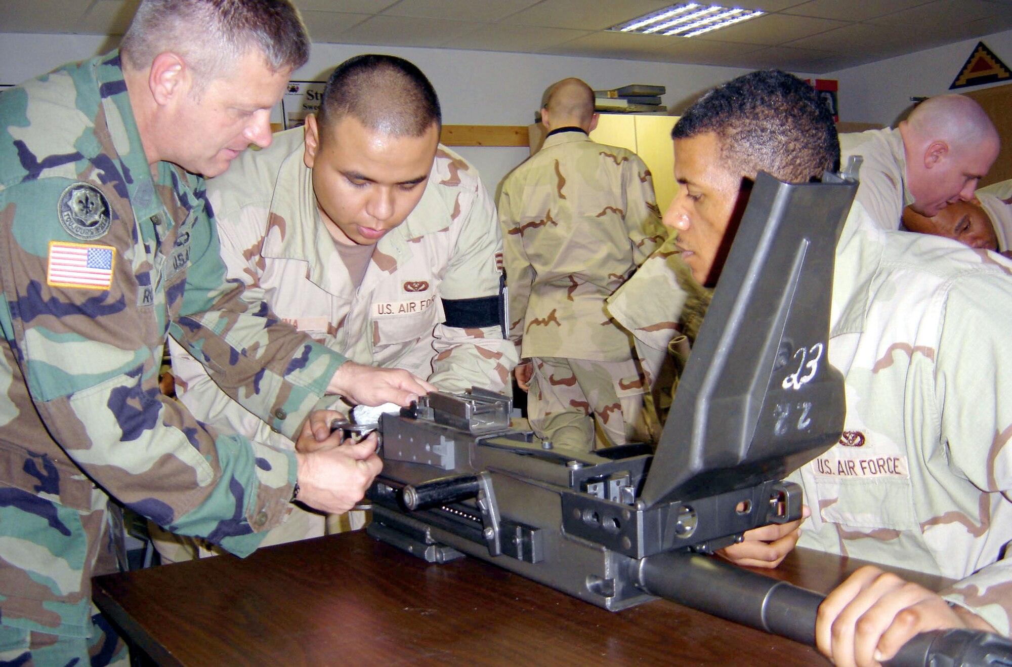 SPANGDAHLEM AIR BASE, Germany -- (From left) Retired Army 1st Sgt. Ernest Roth trains Senior Airman Armando Luna and Airman 1st Class Anthony Greeley on operating and assembling a Mark-19 automatic grenade launcher.  Sergeant Roth is a 7th Army Training Command master gunner.  Airman Luna is an electrical systems journeyman, and Airman Greeley is a structural apprentice.  Both Airmen are assigned to the 52nd Civil Engineer Squadron here.  (U.S. Air Force photo by Capt. Paul Waite)