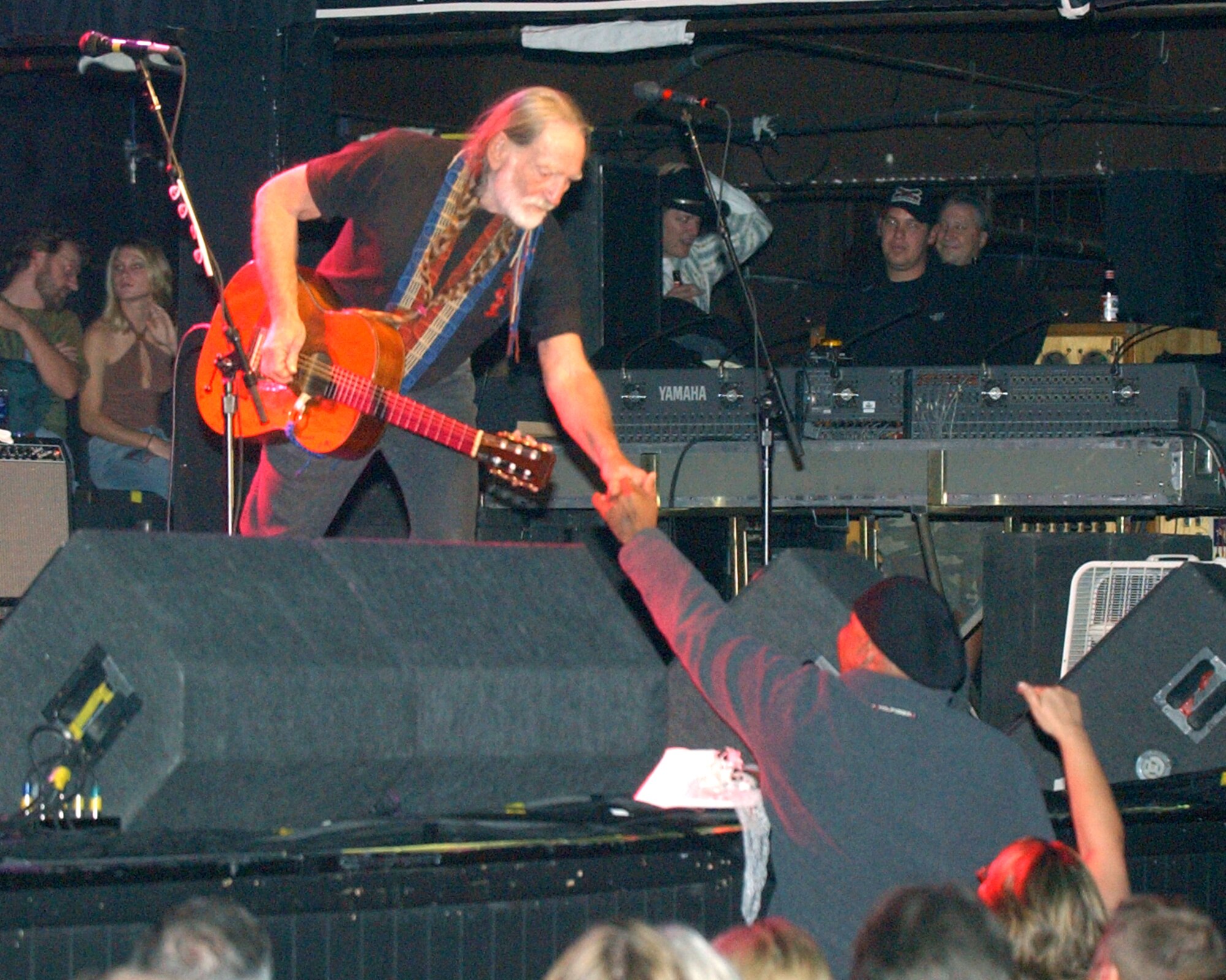 FORT WORTH, Texas -- Army Cpl. J.R. Martinez presents a military coin to Willie Nelson during his concert here Nov. 12.  Corporal Martinez received burn wounds when the Humvee he was driving hit a landmine in Iraq and burst into flames.  (U.S. Air Force photo by Air Force Master Sgt. Lee Roberts)