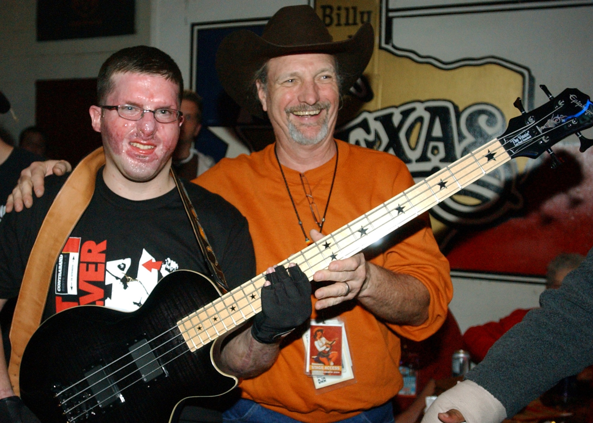 FORT WORTH, Texas -- Army Sgt. Joe Washam poses with bass player Bee Spears following a Willie Nelson concert here Nov. 12.  Sergeant Washam received burn wounds in April while serving in Iraq.  (U.S. Air Force photo by Air Force Master Sgt. Lee Roberts)