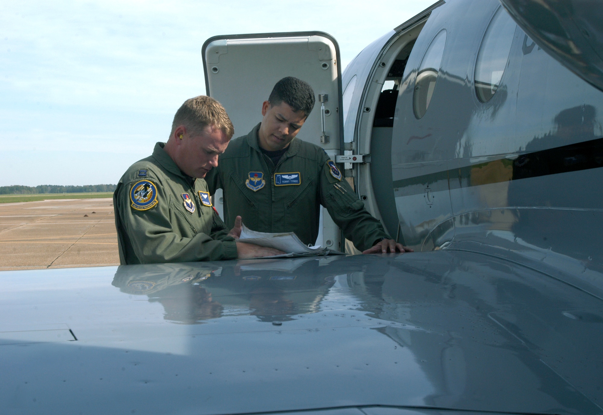 COLUMBUS AIR FORCE BASE, Miss. -- Capt. Stephen Miller (left) reviews aircraft maintenance records with Capt. Terry Tyree Jr. before a flight here.  Captain Tyree earned his third aeronautical rating when he graduated from specialized undergraduate pilot training recently.  He will learn to fly KC-10 Extenders at McGuire Air Force Base, N.J.  Captain Miller was Captain Tyree's flight commander during pilot training.  Captain Miller is assigned to the 48th Flying Training Squadron.  (U.S. Air Force photo by Airman 1st Class Alexis Lloyd)