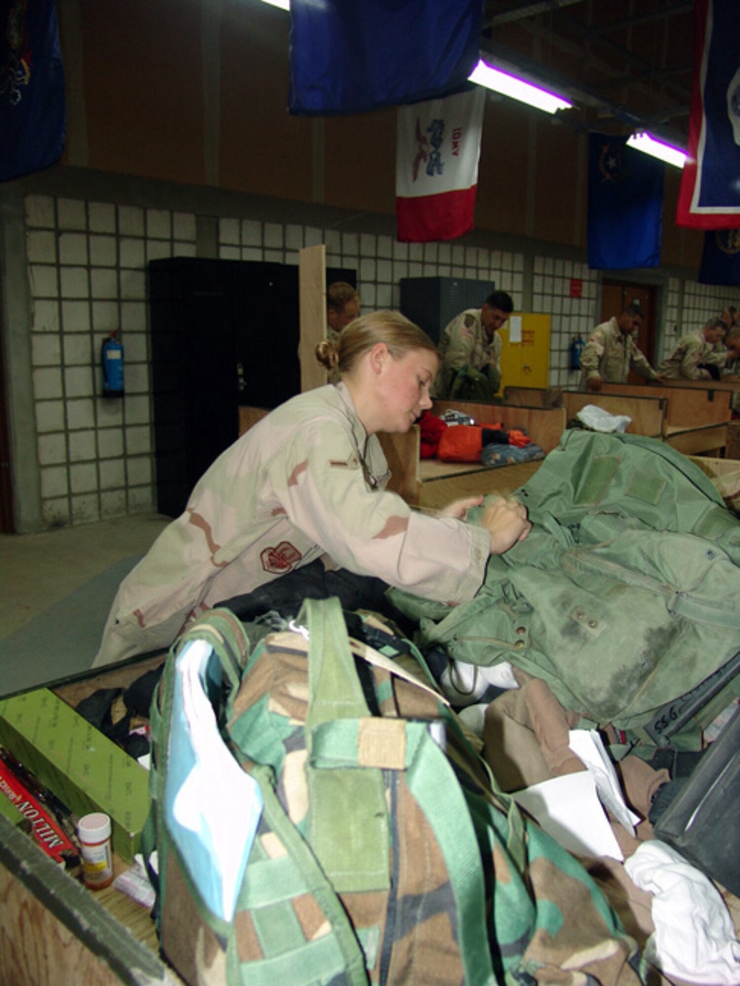 SOUTHWEST ASIA -- Airman Tiffany McLaughlin checks a Soldier's bag before clearing him through customs.  She and other 886th Expeditionary Security Forces Squadron customs inspectors check for prohibited items, such as agricultural products, war souvenirs and ammunition.  (U.S. Air Force photo by Capt. Aaron Burgstein)
