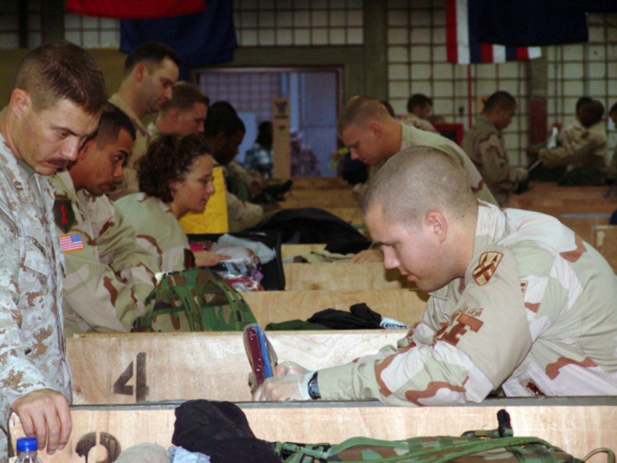 SOUTHWEST ASIA -- Staff Sgt. Dana Hawk checks a Marine's bags before he leaves for the United States.  He and other 886th Expeditionary Security Forces Squadron customs inspectors process about 100 people an hour and up to 1,600 on a busy day.  (U.S. Air Force photo by Capt. Aaron Burgstein) 
