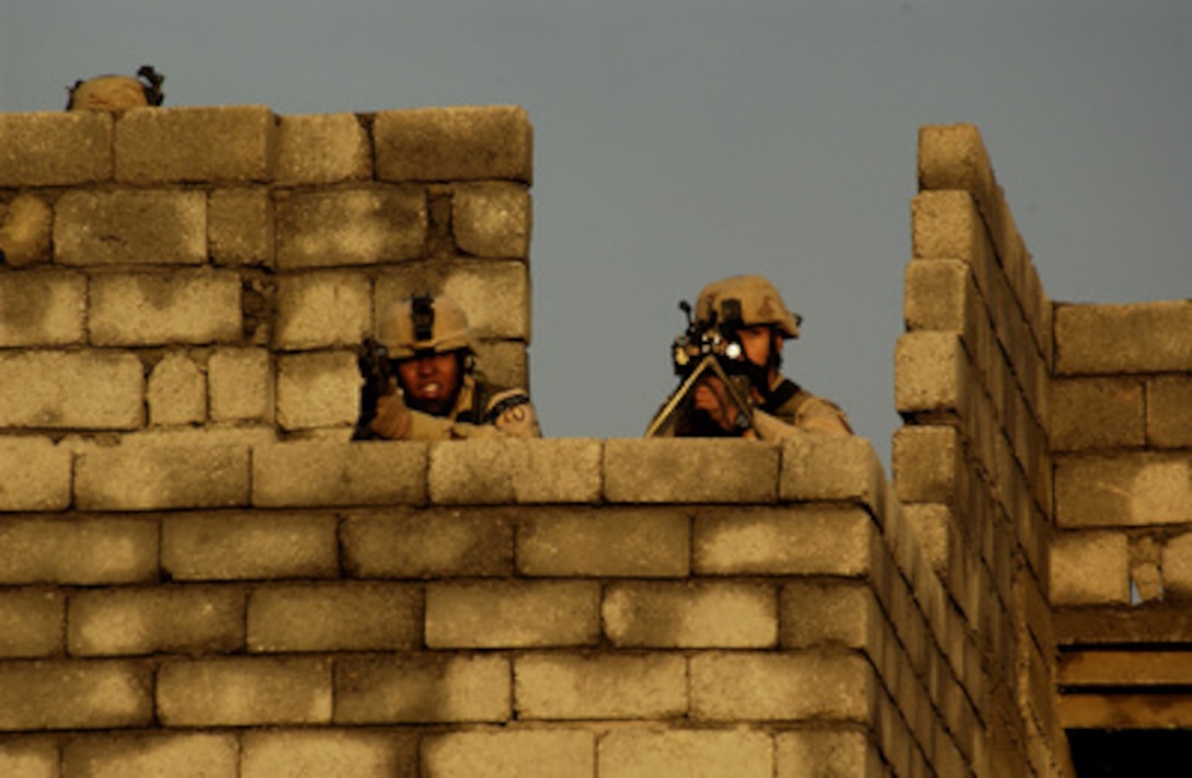 U.S. Army soldiers scan for enemy activity from the top of a building during a combat operation in Mosul, Iraq, on Nov. 9, 2004. Coalition forces are on the offensive searching for and engaging enemy forces. The soldiers are assigned to 1st Battalion, 24th Infantry Regiment, 1st Brigade, 25th Infantry Division, Stryker Brigade Combat Team. 