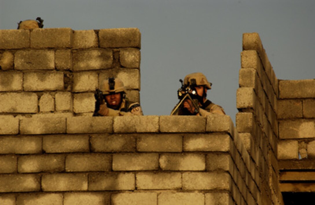 U.S. Army soldiers scan for enemy activity from the top of a building during a combat operation in Mosul, Iraq, on Nov. 9, 2004. Coalition forces are on the offensive searching for and engaging enemy forces. The soldiers are assigned to 1st Battalion, 24th Infantry Regiment, 1st Brigade, 25th Infantry Division, Stryker Brigade Combat Team. 