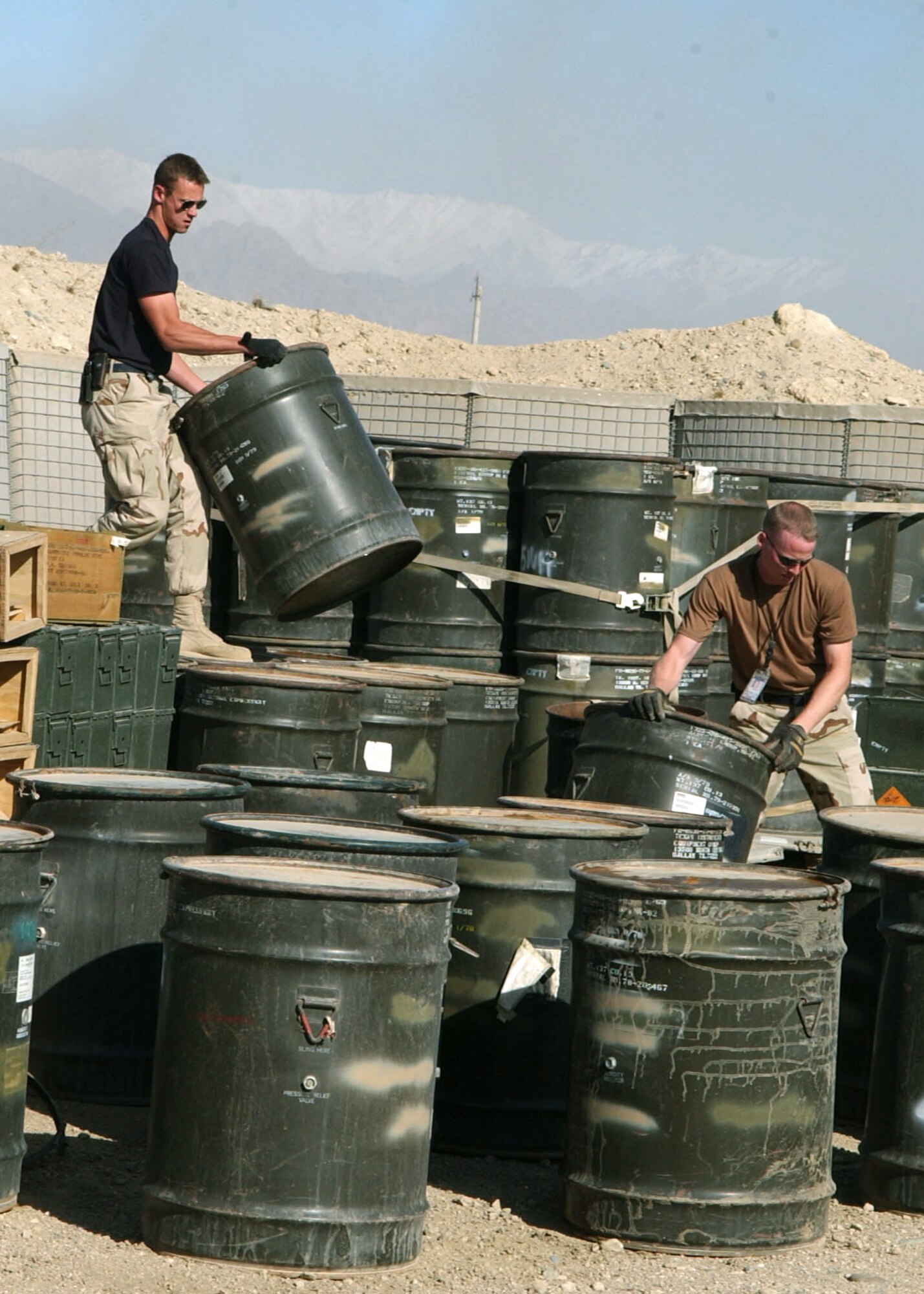 BAGRAM AIR BASE, Afghanistan -- Airman 1st Class Daniel Sewell (left) and Staff Sgt. Zachary Daugherty inspect and sort ammunition storage containers to ensure they are empty before they are crushed.  The active-duty 455th Expeditionary Aircraft Maintenance Squadron ammunitions unit Airmen are deployed to Afghanistan from Spangdahlem Air Base, Germany.  (U.S. Air Force photo by Staff Sgt. Jennifer Lindsey)