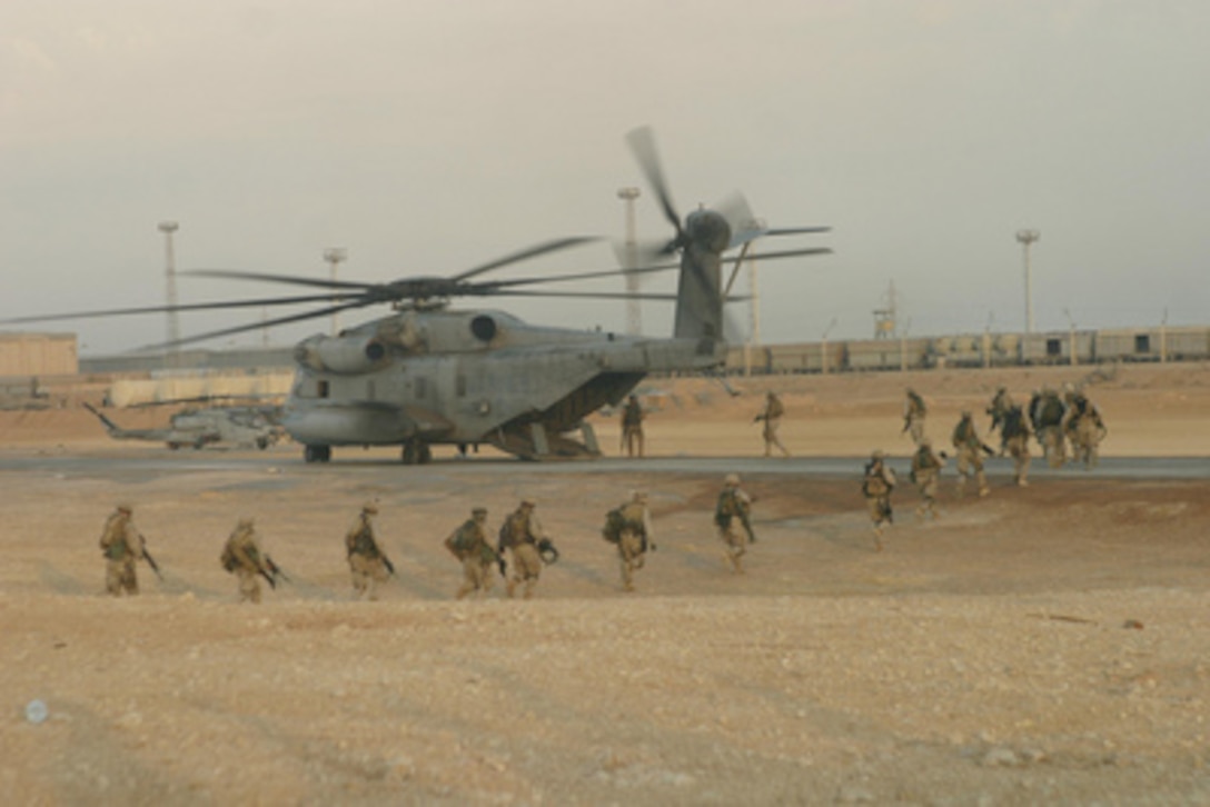 U.S. Marines board a CH-53 Sea Stallion helicopter at Forward Operating Base Camp Al Qaim in Iraq during Operation al Fajr (New Dawn) on Nov. 10, 2004. The Marines from the 1st Battalion, 7th Marine Regiment are engaged in security and stabilization operations in the Al Anbar province. 